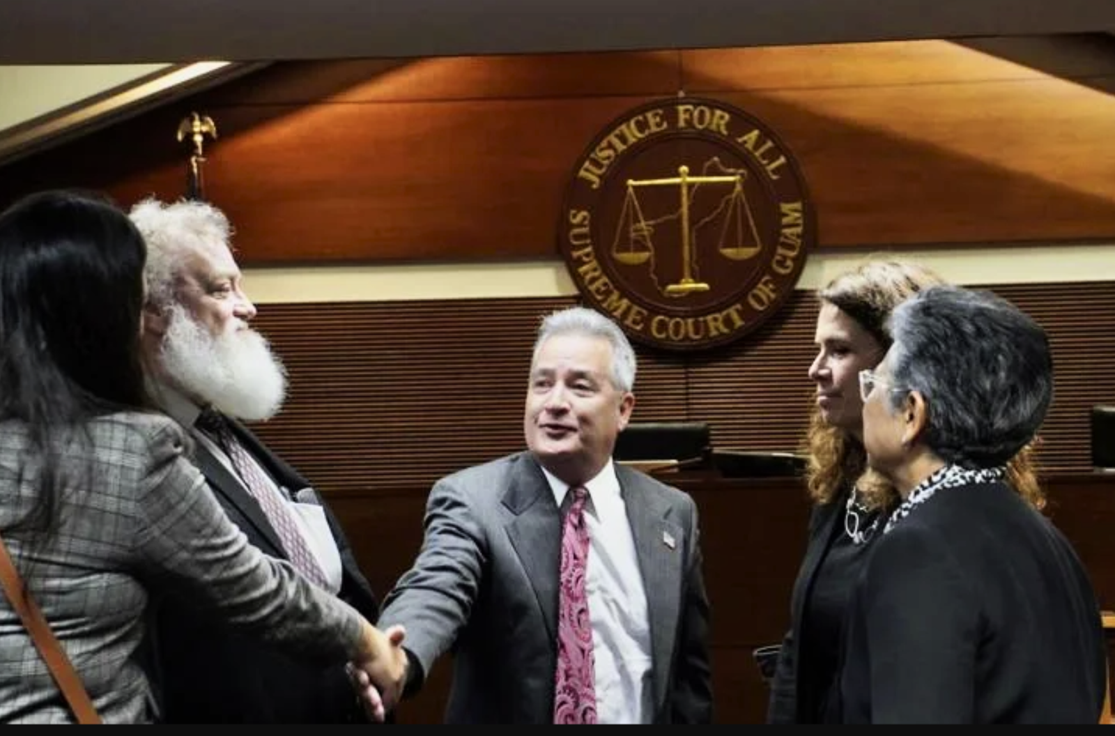 Attorney General Douglas Moylan, center, shakes hands with several other attorneys at a Supreme Court of Guam status conference Wednesday, April 12, 2023, at the Guam Judicial Center in Hagåtña. 