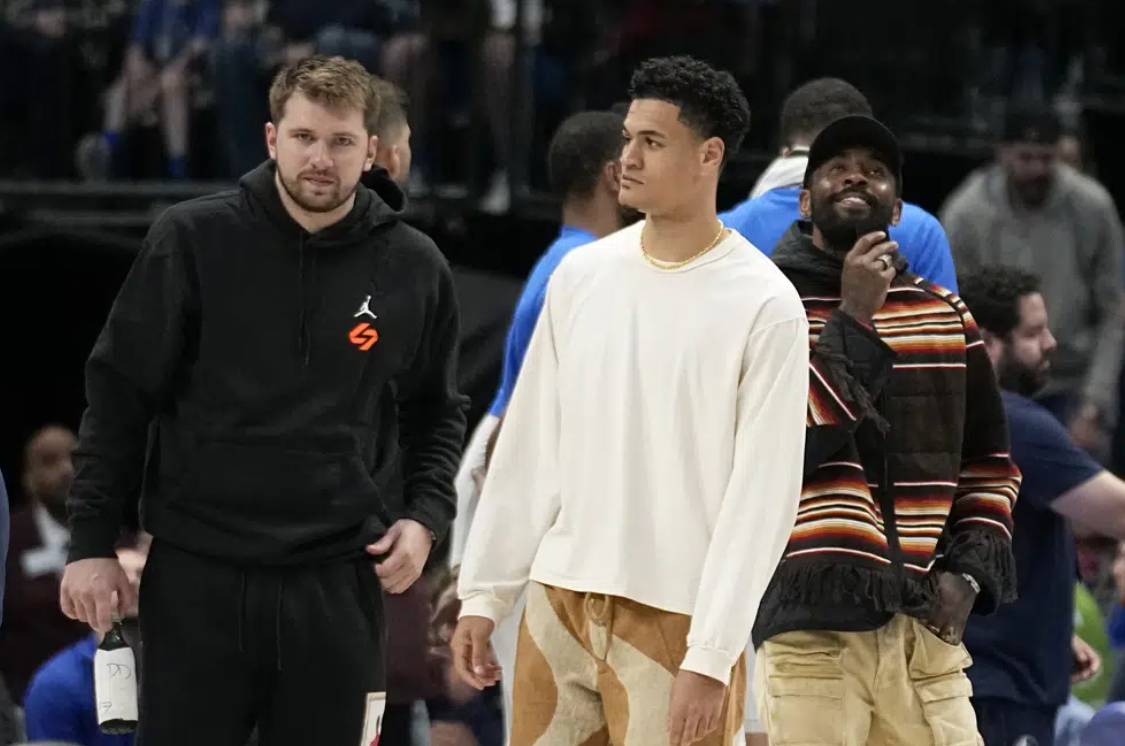 Dallas Mavericks' Luka Doncic, left, Josh Green, center, and Kyrie Irving, right, stand on the court during a timeout in the second half of an NBA basketball game against the Chicago Bulls, Friday, April 7, 2023, in Dallas.