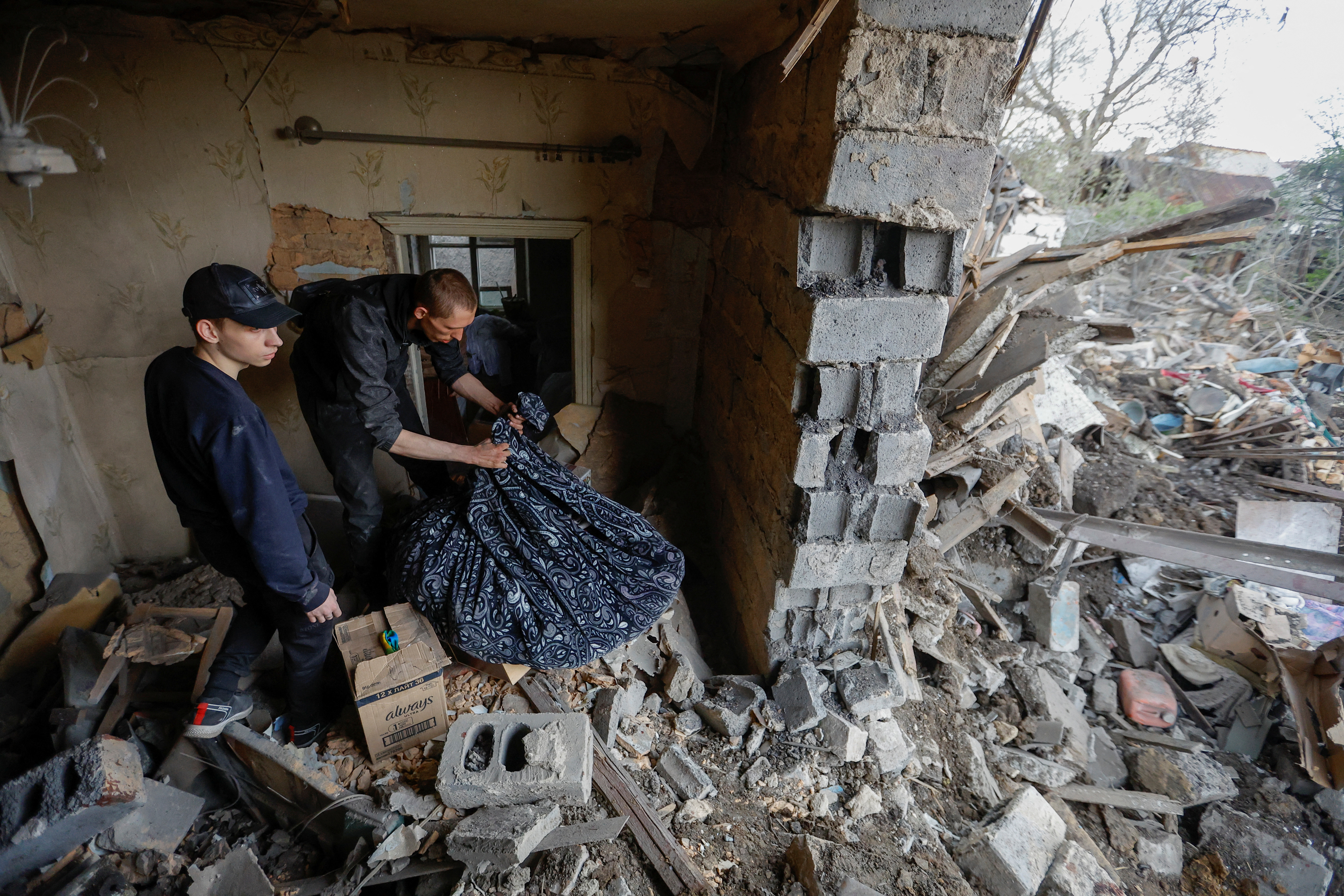 Local residents carry belongings out of their house destroyed by shelling in the course of Russia-Ukraine conflict in Donetsk, Russian-controlled Ukraine, April 29, 2023. REUTERS/Alexander Ermochenko