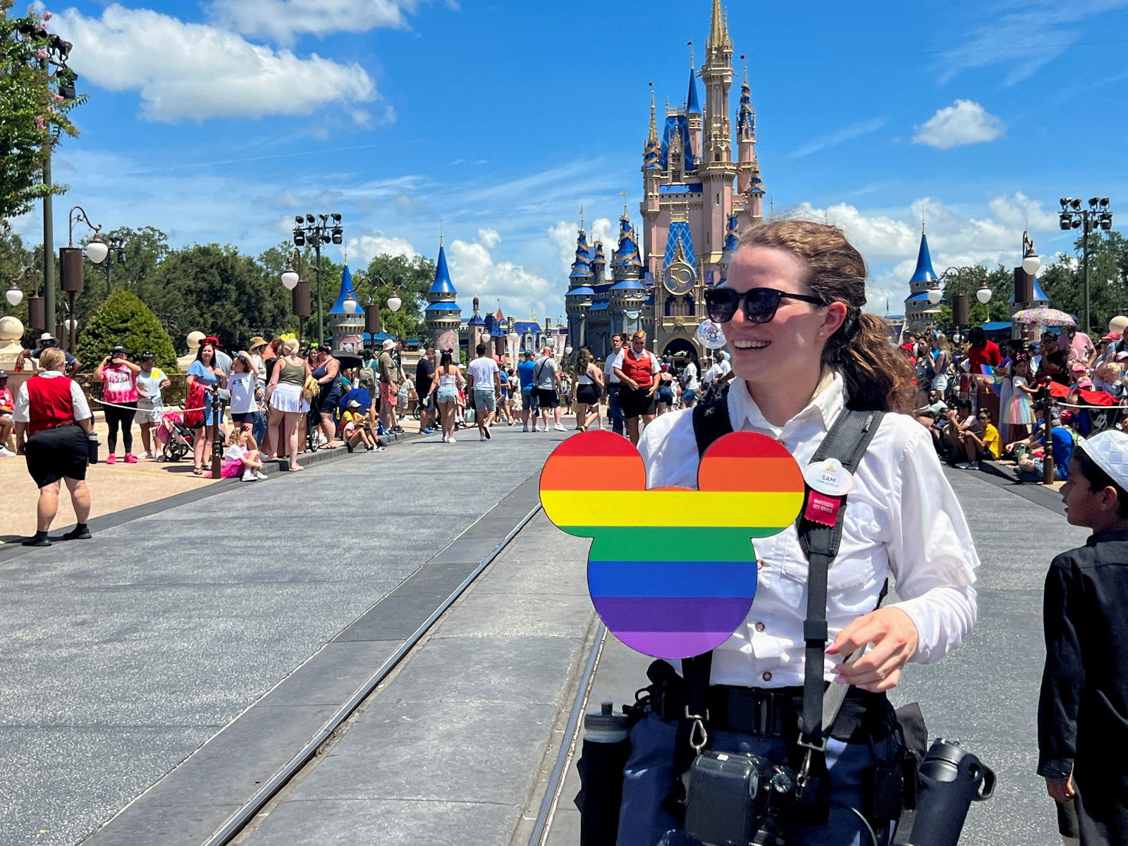 A Walt Disney World photographer holds a Pride rainbow-colored Mickey Mouse cutout before the "Festival of Fantasy" parade at the Walt Disney World Magic Kingdom theme park in Orlando, Florida, July 30, 2022.