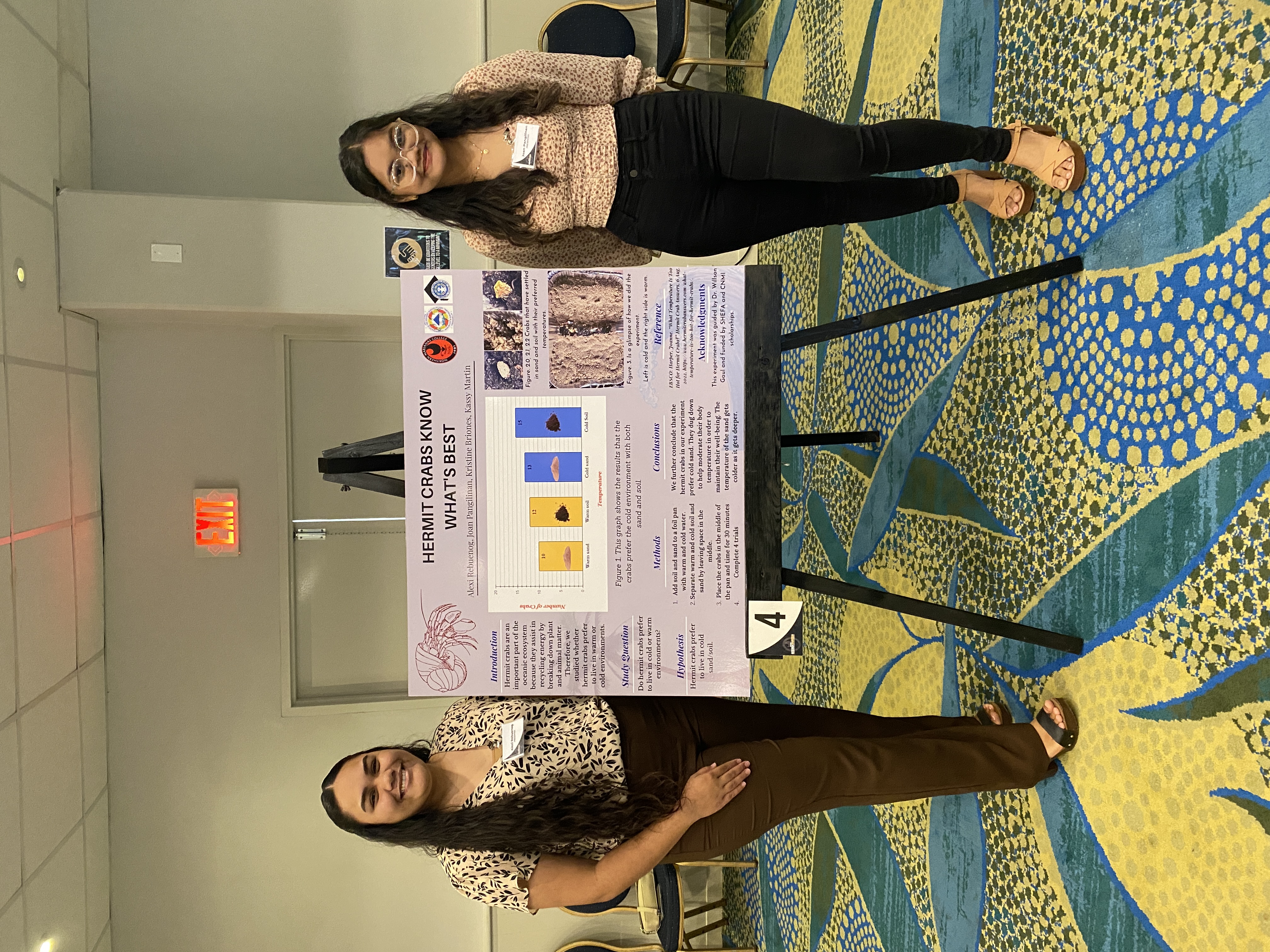Alexi Rebuenog and Joan Pangilinan stand with their research presentation titled "Hermit crabs know best."