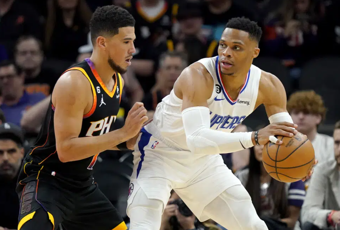 Los Angeles Clippers guard Russell Westbrook backs down Phoenix Suns guard Devin Booker, left, during the second half of Game 1 of a first-round NBA basketball playoff series, Sunday, April 16, 2023, in Phoenix.