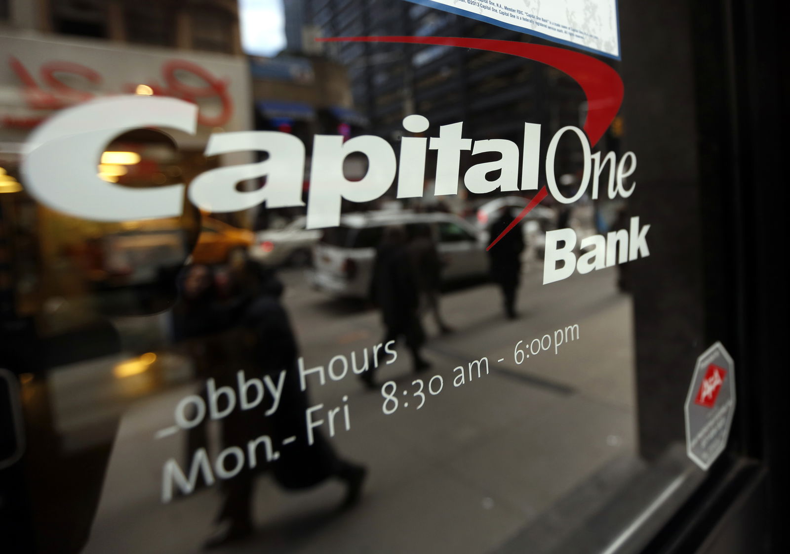 People walk past a Capital One banking center in New York's financial district, Jan. 17, 2013.