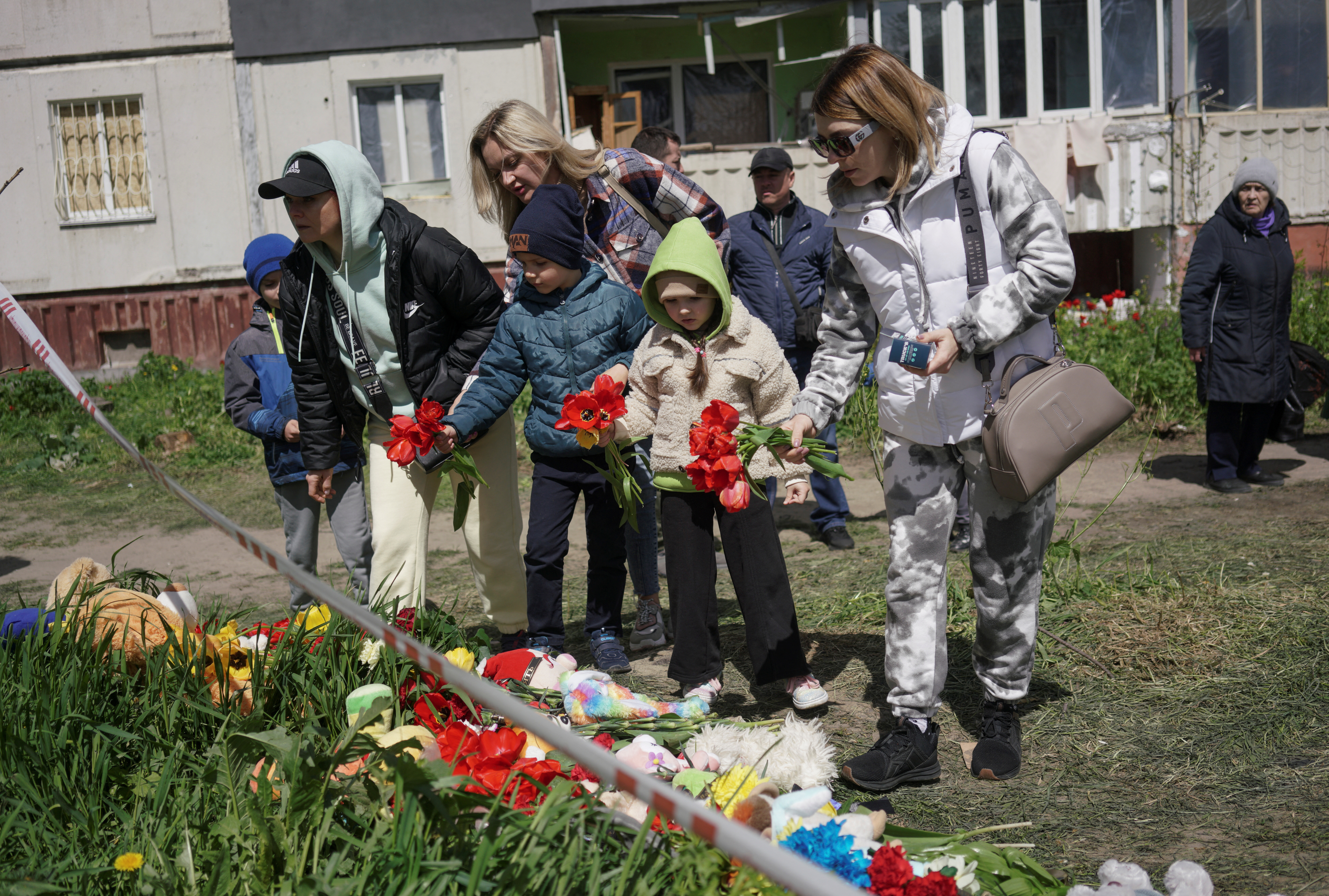 Local residents place flowers to pay tribute to civilian people killed yesterday by a Russian missile strike, amid Russia's attack on Ukraine, at a strike site in the town of Uman, Cherkasy region, Ukraine April 29, 2023. REUTERS/Anna Voitenko