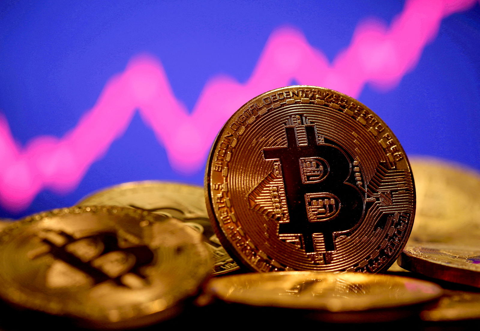 FILE PHOTO: A representation of virtual currency Bitcoin is seen in front of a stock graph in this illustration taken January 8, 2021. REUTERS/Dado Ruvic/File Photo