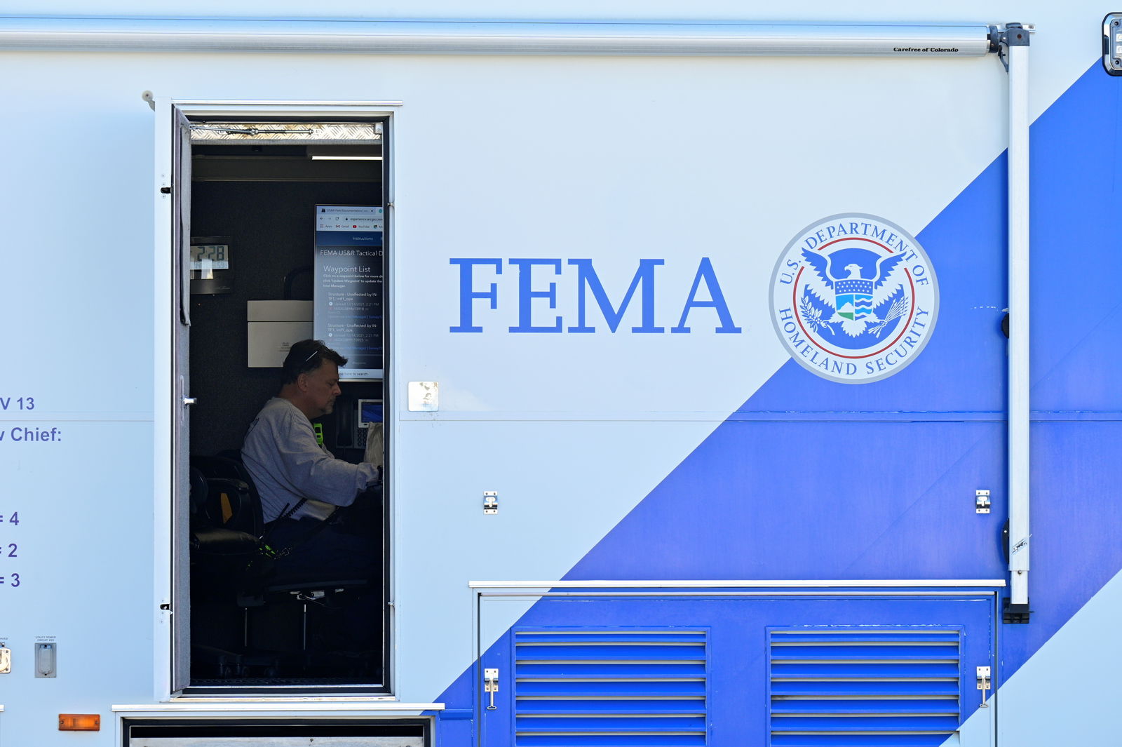 FILE PHOTO: A person sits at a desk inside of a mobile FEMA command center in downtown Dawson Springs, Kentucky, U.S., December 14, 2021. REUTERS/Jon Cherry