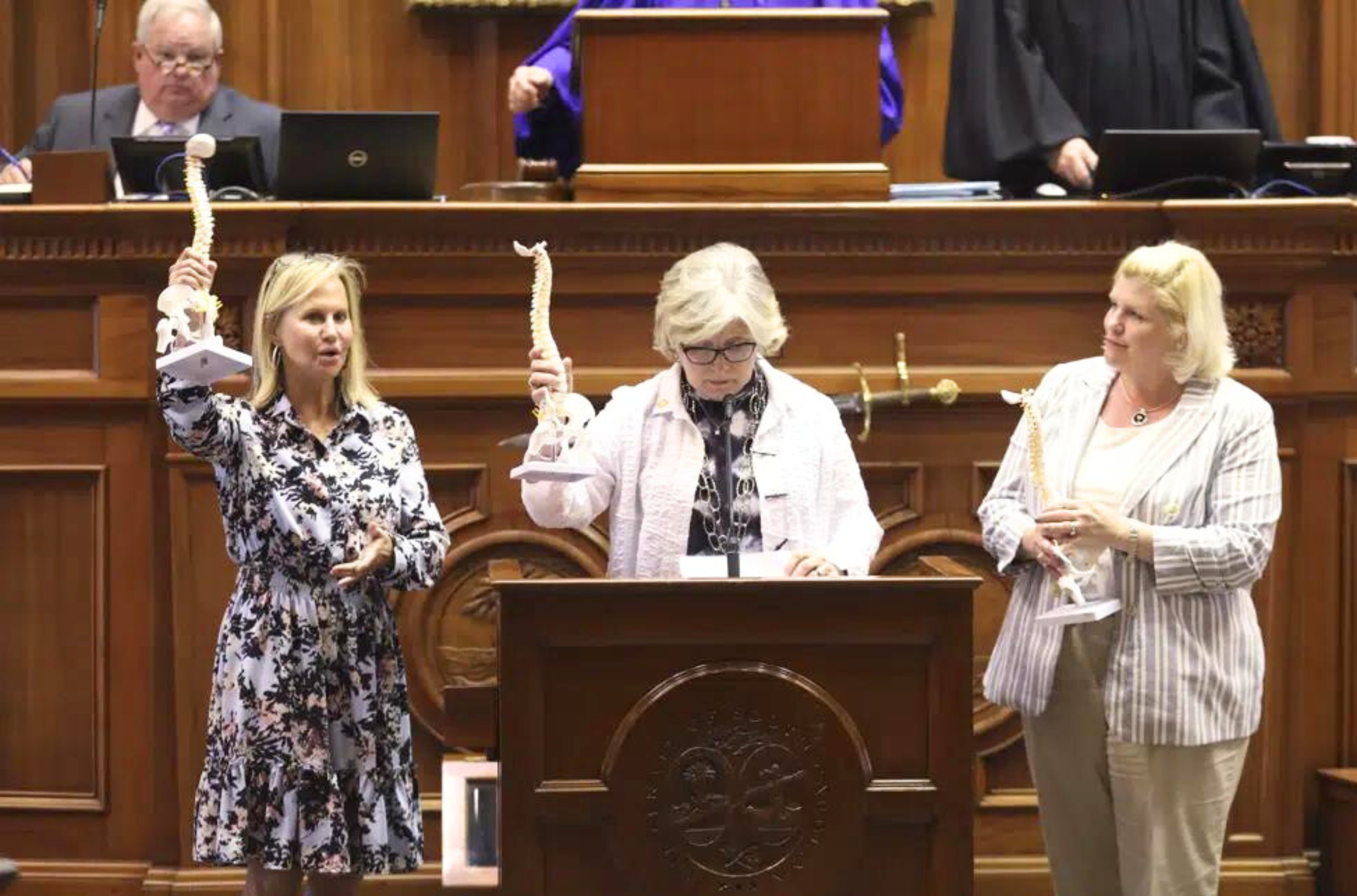 From left, South Carolina Sens. Sandy Senn, R-Charleston, Katrina Shealy, R-Lexington, center, and Penry Gustafson, R-Camden, show off model spines they were sent by groups who want to outlaw almost all abortions. The senators say the spines won't change their mind when the issue is debated next week.