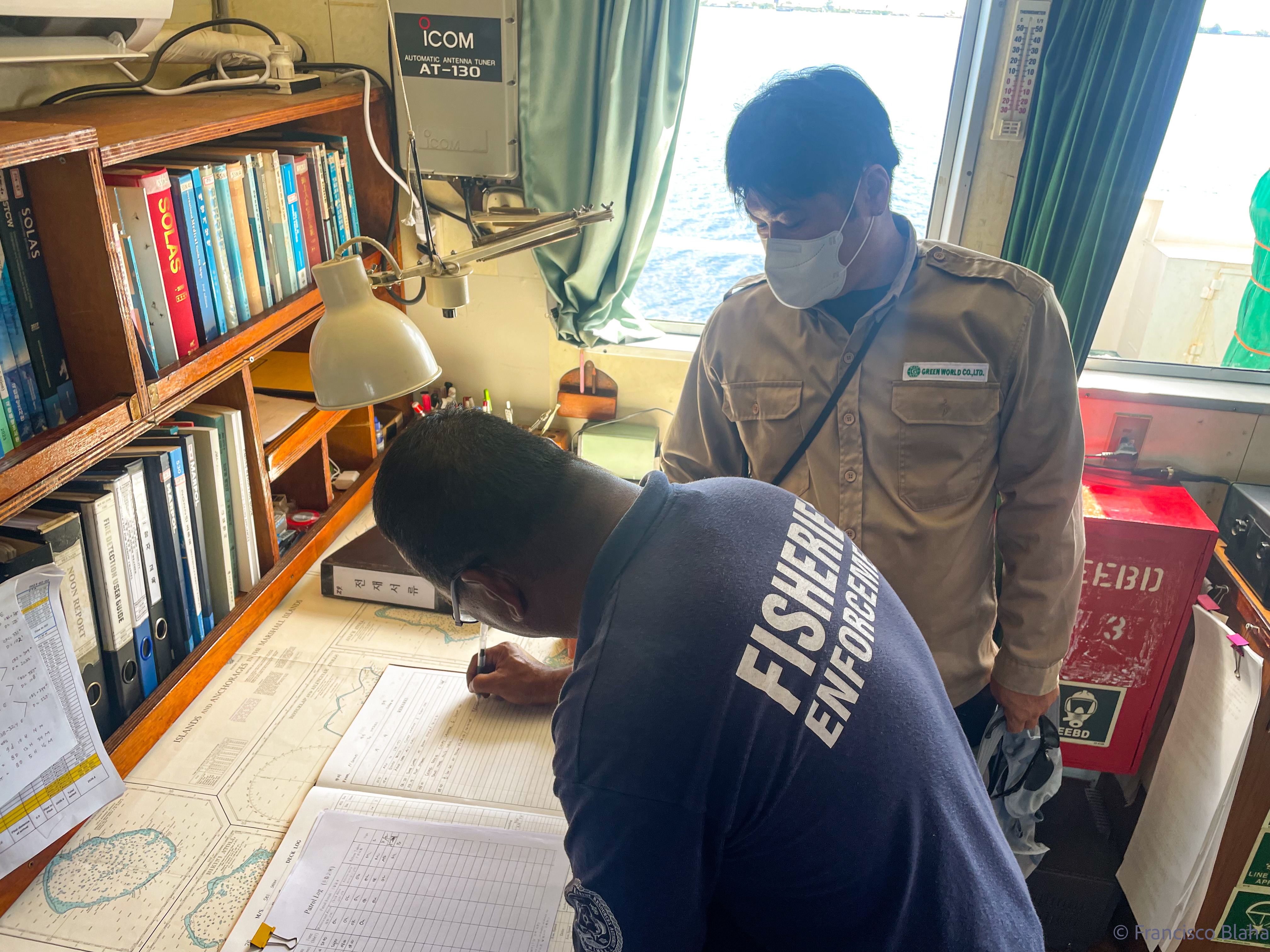 Fisheries monitoring and compliance officer Stevenson Graham reviews the log of a purse seiner during a routine boarding and inspection by Marshall Islands Marine Resources Authority officers.