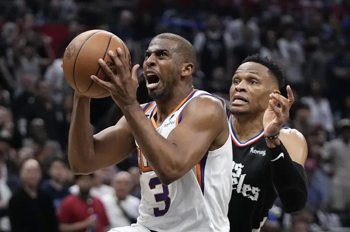 Phoenix Suns guard Chris Paul, left, shoots as Los Angeles Clippers guard Russell Westbrook defends during the second half in Game 4 of a first-round NBA basketball playoff series Saturday, April 22, 2023, in Los Angeles.