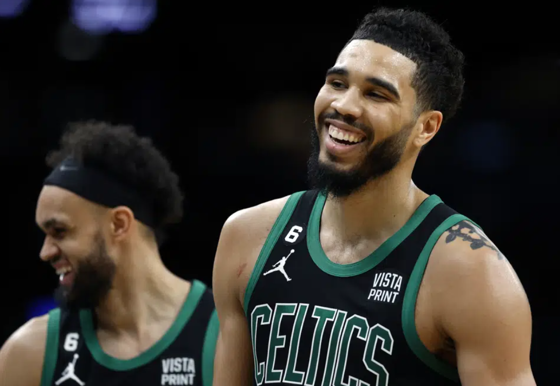 Boston Celtics' Jayson Tatum, right, and Derrick White react during the first half of the team's NBA basketball game against the Toronto Raptors, Friday, April 7, 2023, in Boston.