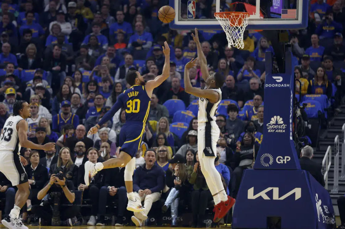Golden State Warriors guard Stephen Curry (30) shoots against San Antonio Spurs guard Malaki Branham, right, during the first half of an NBA basketball game in San Francisco, Friday, March 31, 2023.