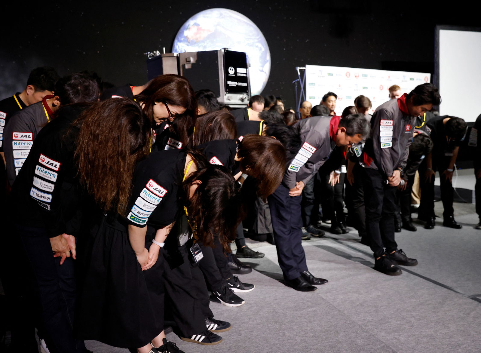 Employees of "ispace" bow their heads after the company announced they lost signal from the lander in HAKUTO-R lunar exploration program on the Moon at a venue to watch its landing in Tokyo, Japan, April 26, 2023. REUTERS/Kim Kyung-Hoon