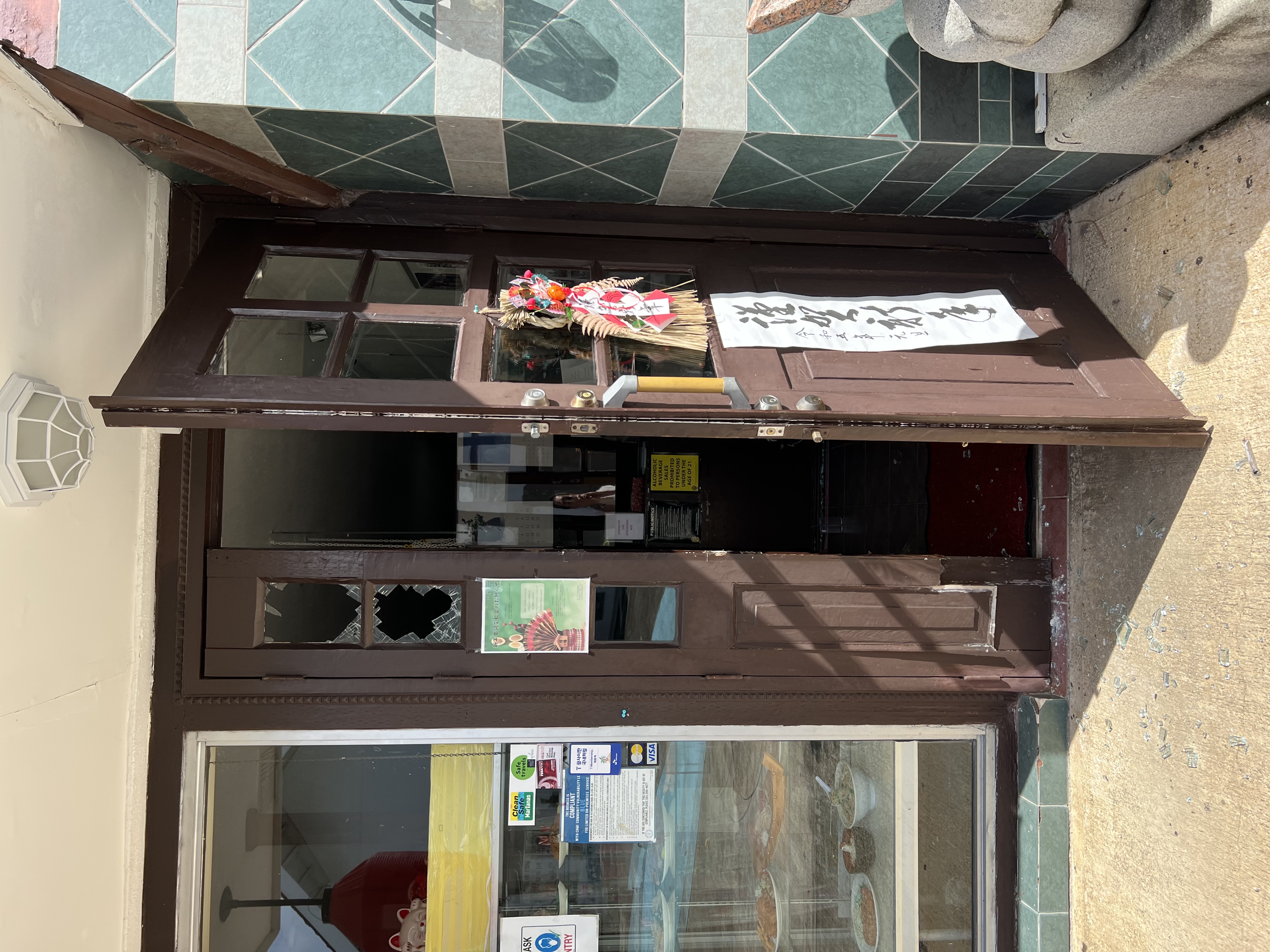 The damaged door of Furusato Restaurant is seen in January.