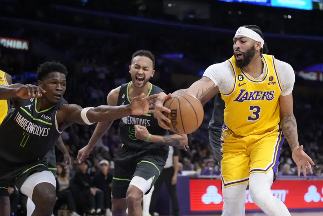 Los Angeles Lakers forward Anthony Davis (3) reaches for the ball next to Minnesota Timberwolves guard Anthony Edwards (1) and forward Kyle Anderson during the first half of an NBA basketball play-in tournament game Tuesday, April 11, 2023, in Los Angeles.