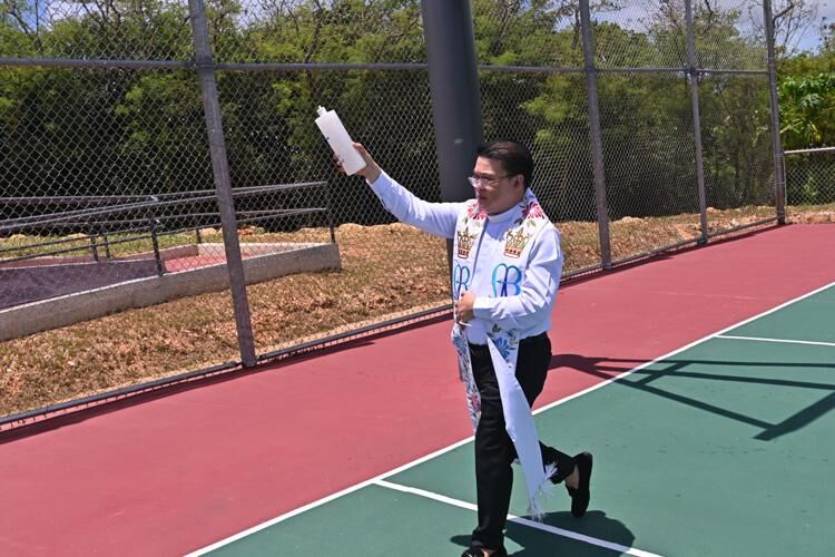 Rev. Joseph Anore blesses the court with holy water at the Inalåhan basketball court ribbon-cutting ceremony Monday, April 17, 2023, in Inalåhan.  