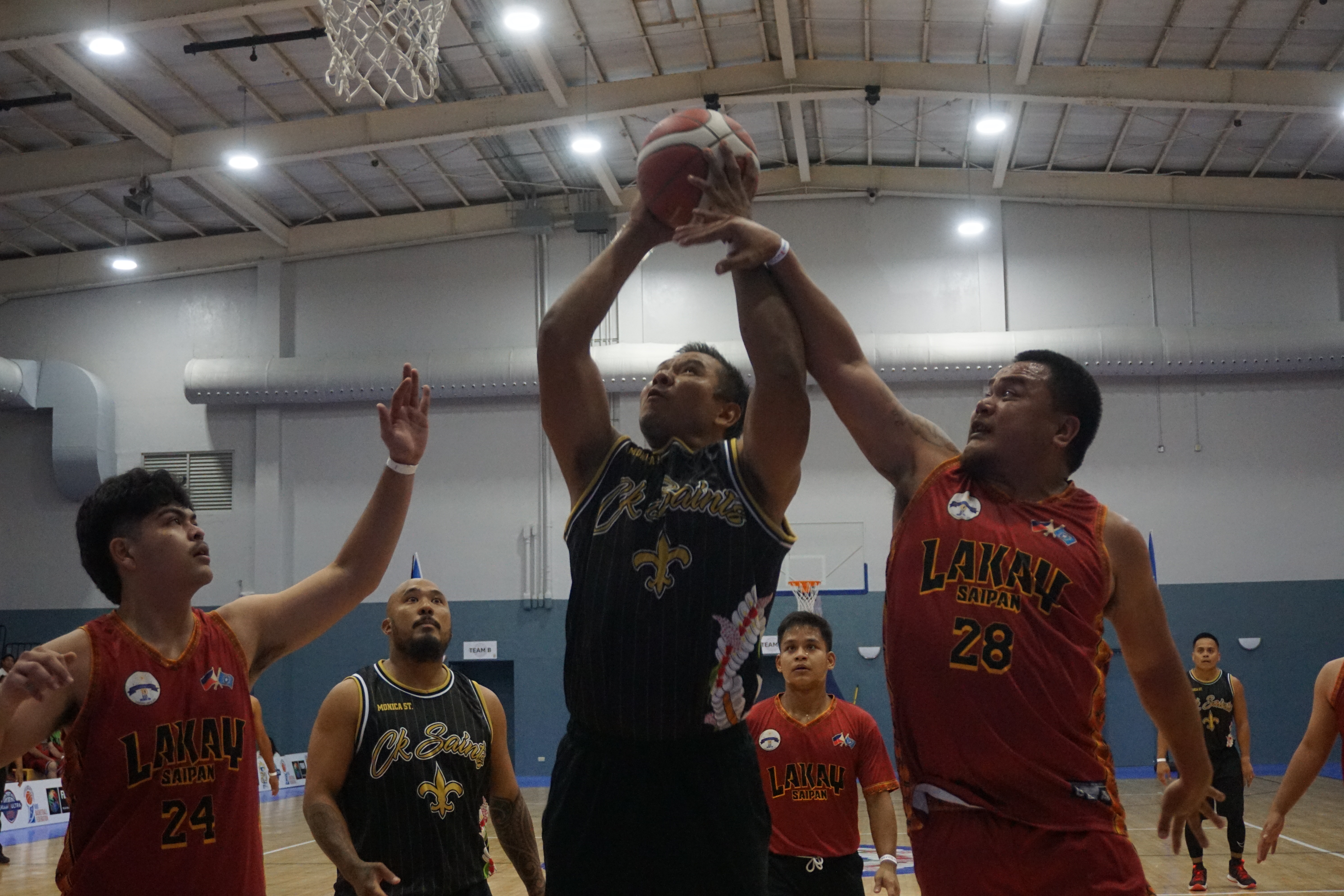 CK Saint's Mel Manibusan gets into contact as he goes up for the finish against Save More's Pete Lizama  during the opening game of the Michelob Ultra Cup 2023 Tuesday at the Ada gym.