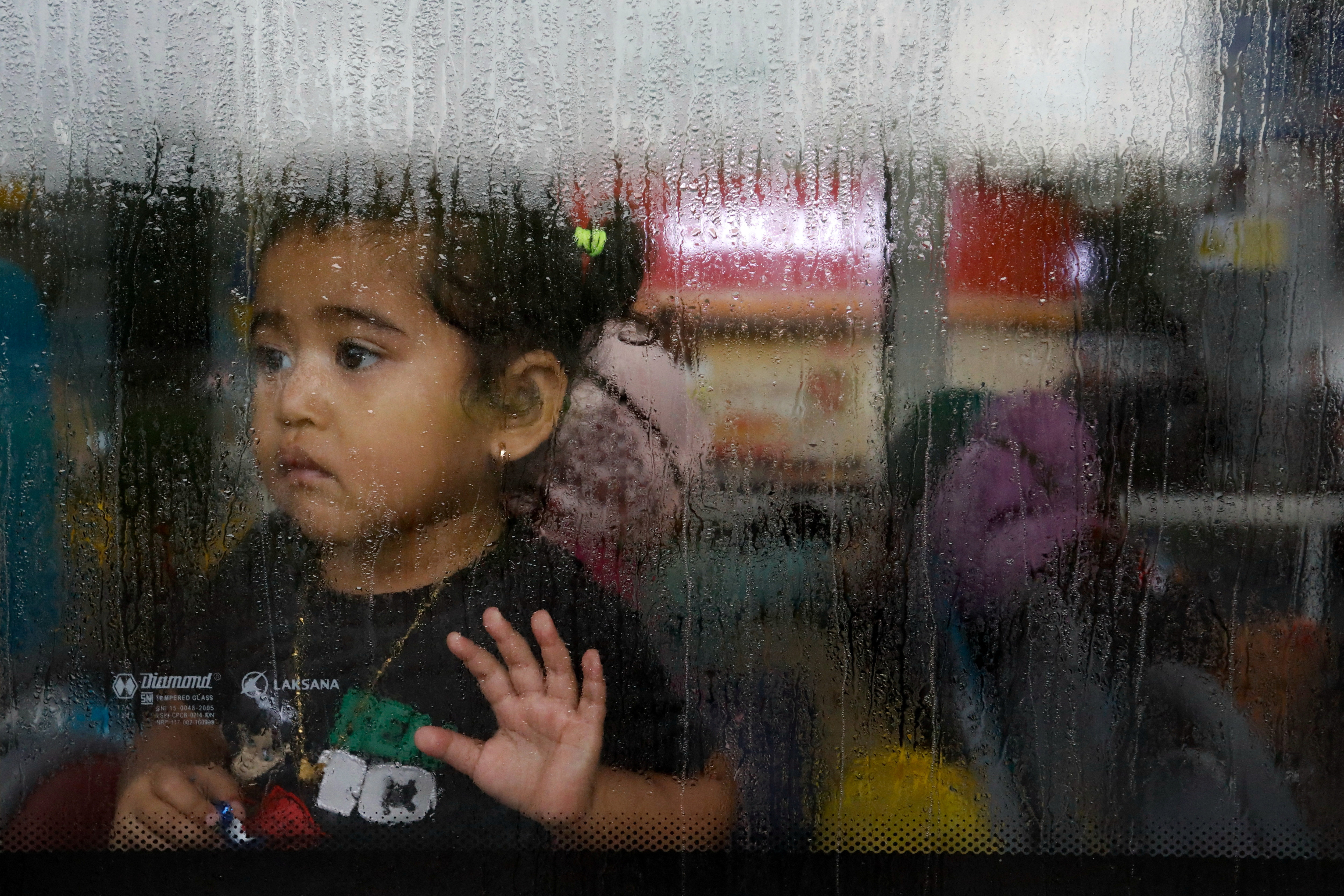 A girl evacuated from Sudan looks through the window of a bus after she arrives at the Soekarno-Hatta Airport in Tangerang, on the outskirts of Jakarta, Indonesia, April 28, 2023. REUTERS/Ajeng Dinar Ulfiana
