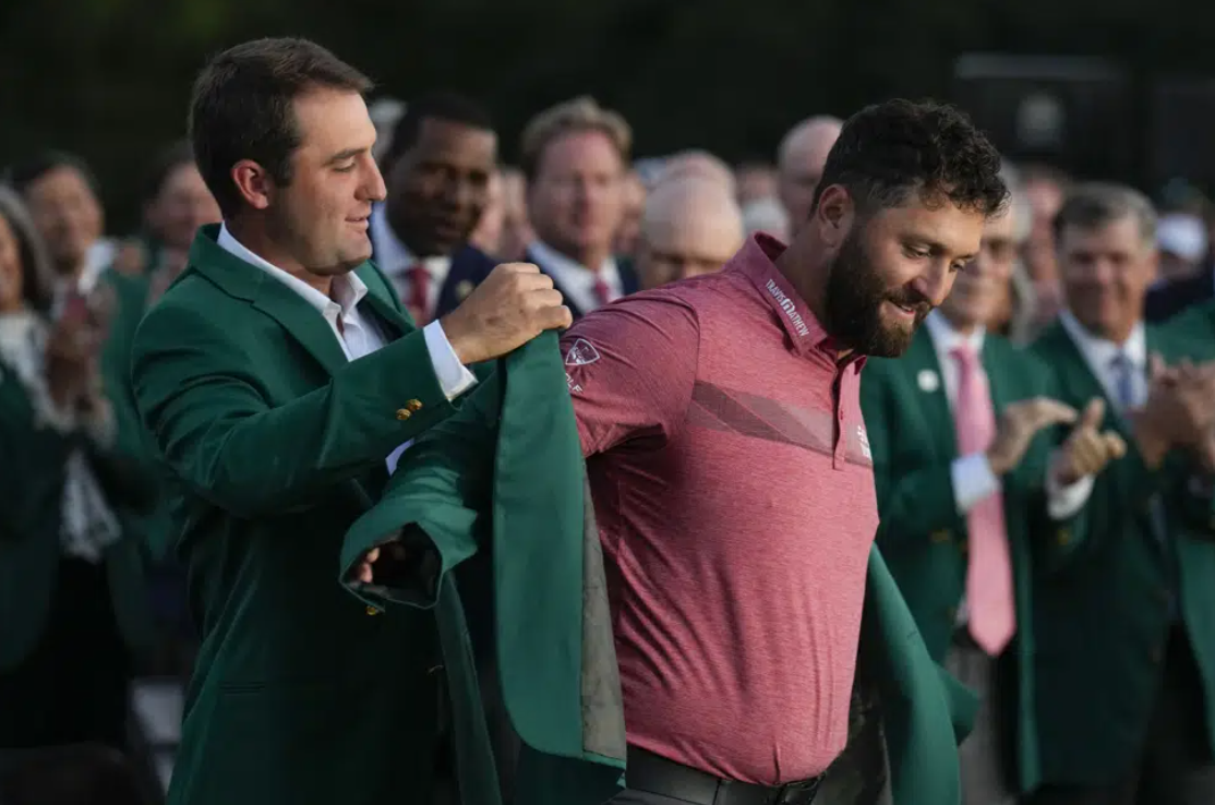 Scottie Scheffler puts the green jacket on Jon Rahm of Spain after Rahm won the Masters golf tournament at Augusta National Golf Club on Sunday, April 9, 2023, in Augusta, Ga.