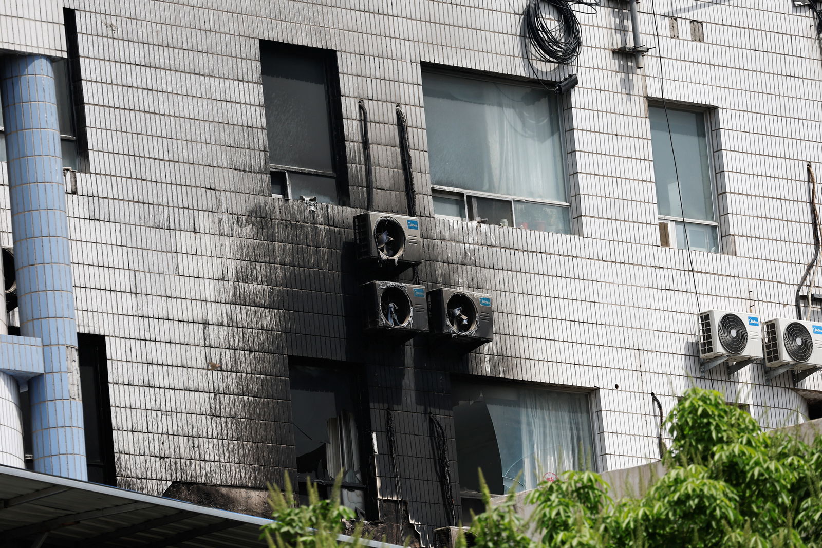 Damaged windows and external air-conditioning fans are seen following a fire that occurred at the Changfeng Hospital, in Beijing, China April 19, 2023. REUTERS/Tingshu Wang