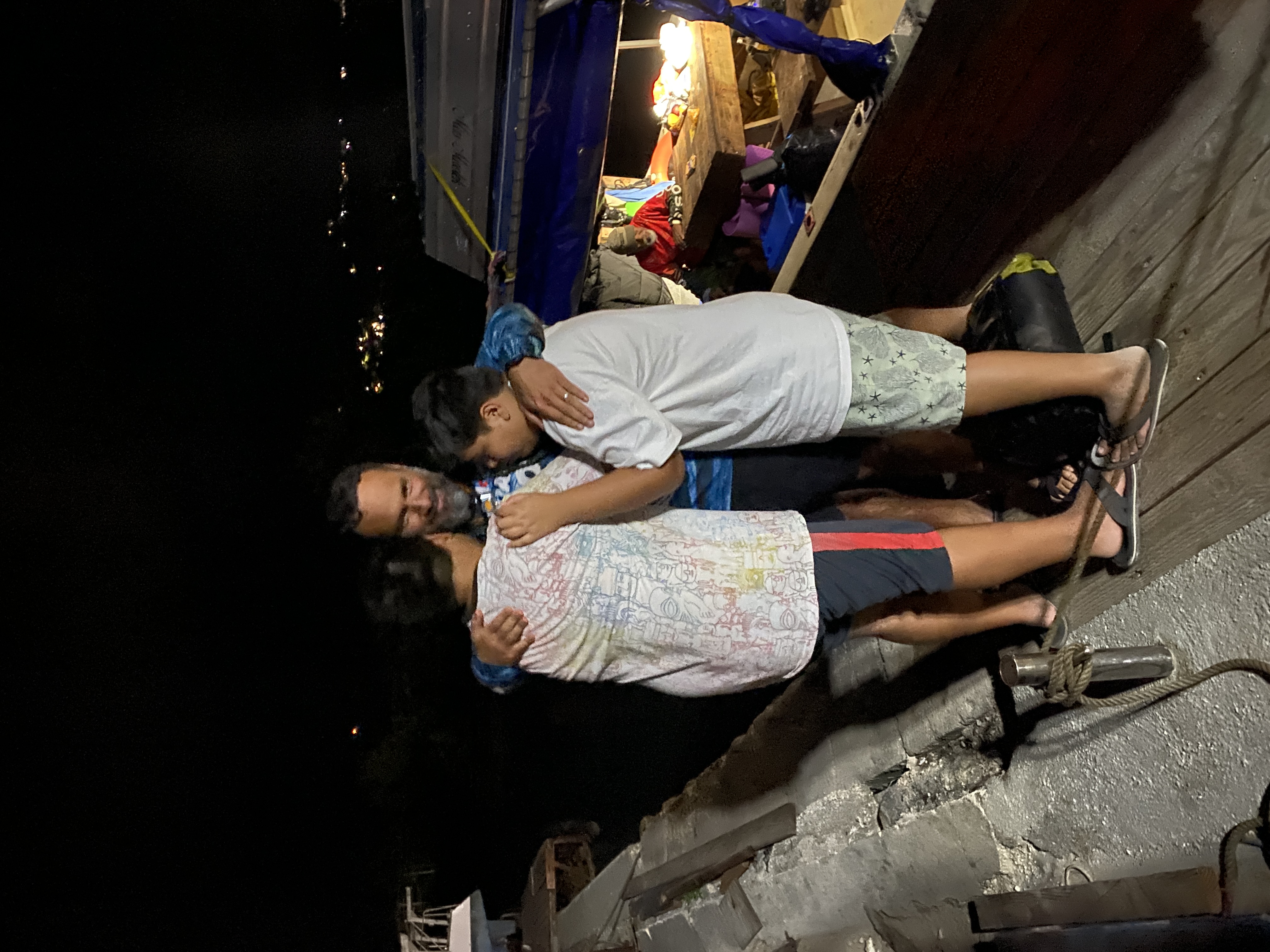 Leo Pangelinan, executive director of the Northern Marianas Humanities Council, embraces his sons after arriving on Saipan on April 13, 2023.