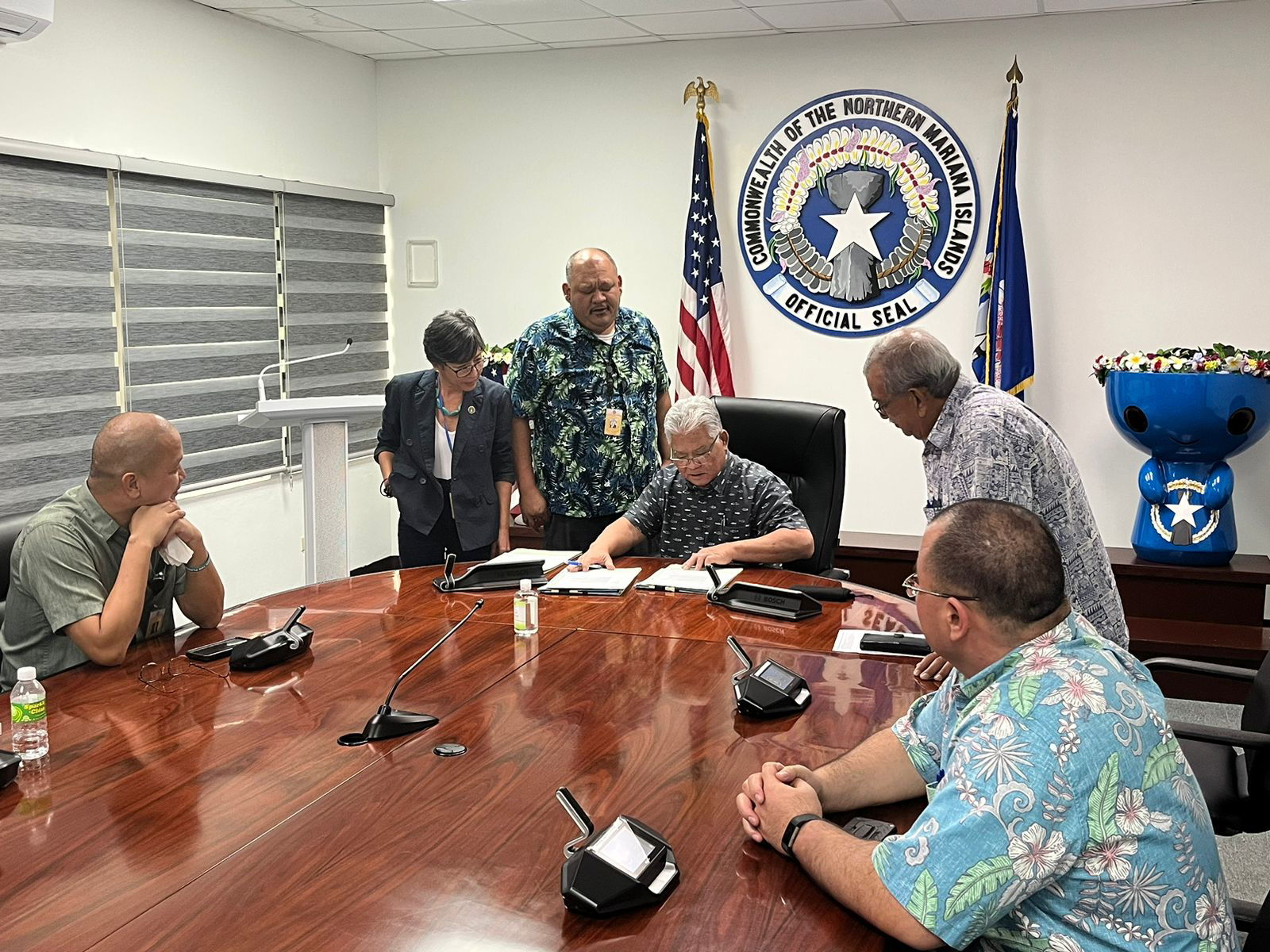 Gov. Arnold I. Palacios reads a House bill as Reps. Vincent "Kobre" Aldan, Marissa Flores, John Paul Sablan, Special Assistant for Administration Oscar M. Babauta and Speaker Edmund S. Villagomez look on.