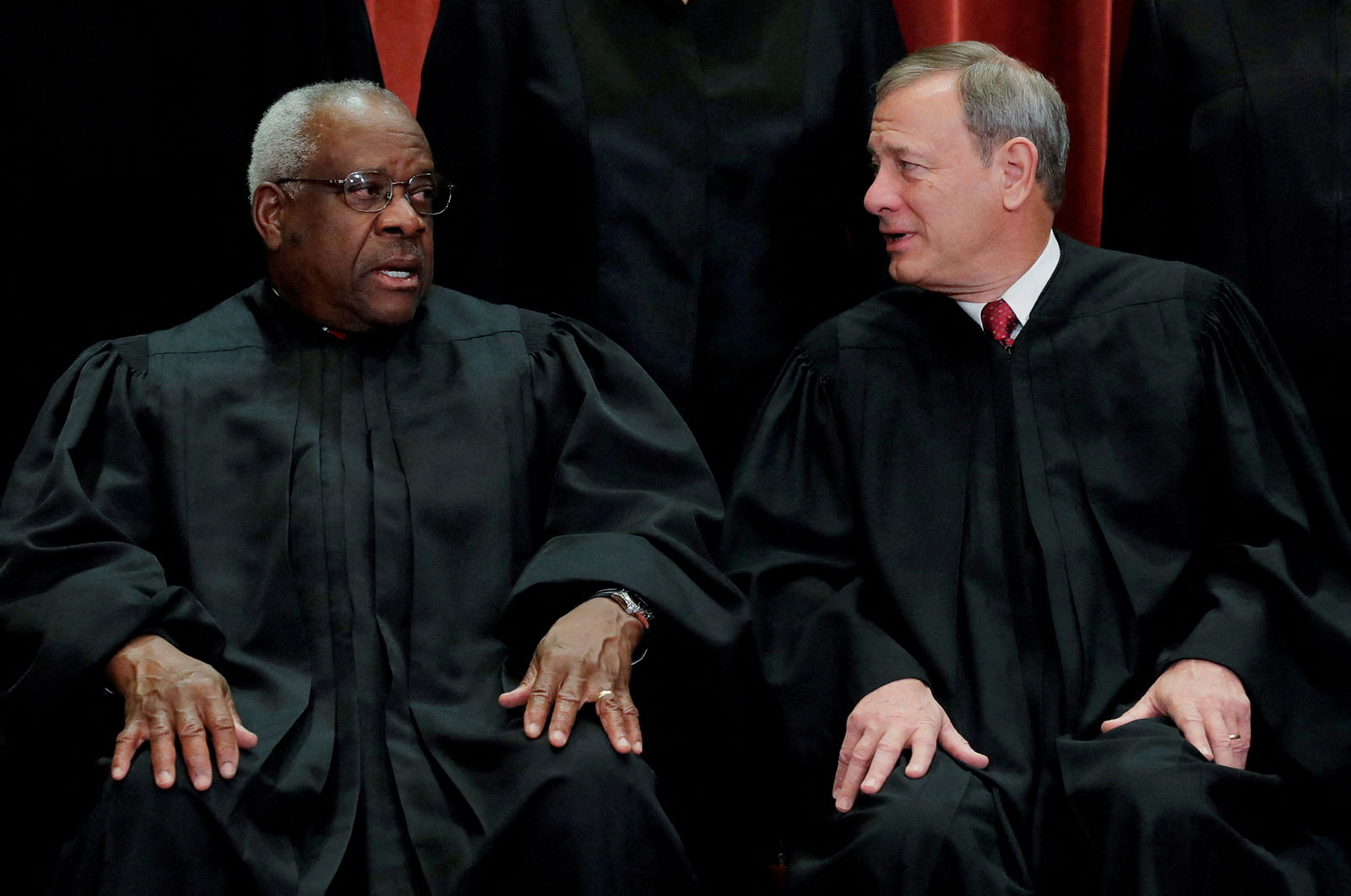 FILE PHOTO: U.S. Supreme Court Associate Justice Clarence Thomas (L) talks with Chief Justice John Roberts as the justices pose for their group portrait at the Supreme Court in Washington, U.S., November 30, 2018. REUTERS/Jim Young/File Photo