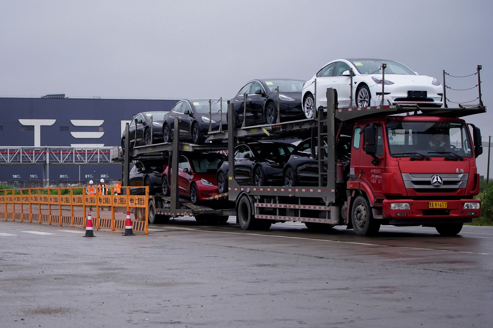 FILE PHOTO: A truck transports new Tesla cars at its factory in Shanghai, China May 13, 2021. REUTERS/Aly Song