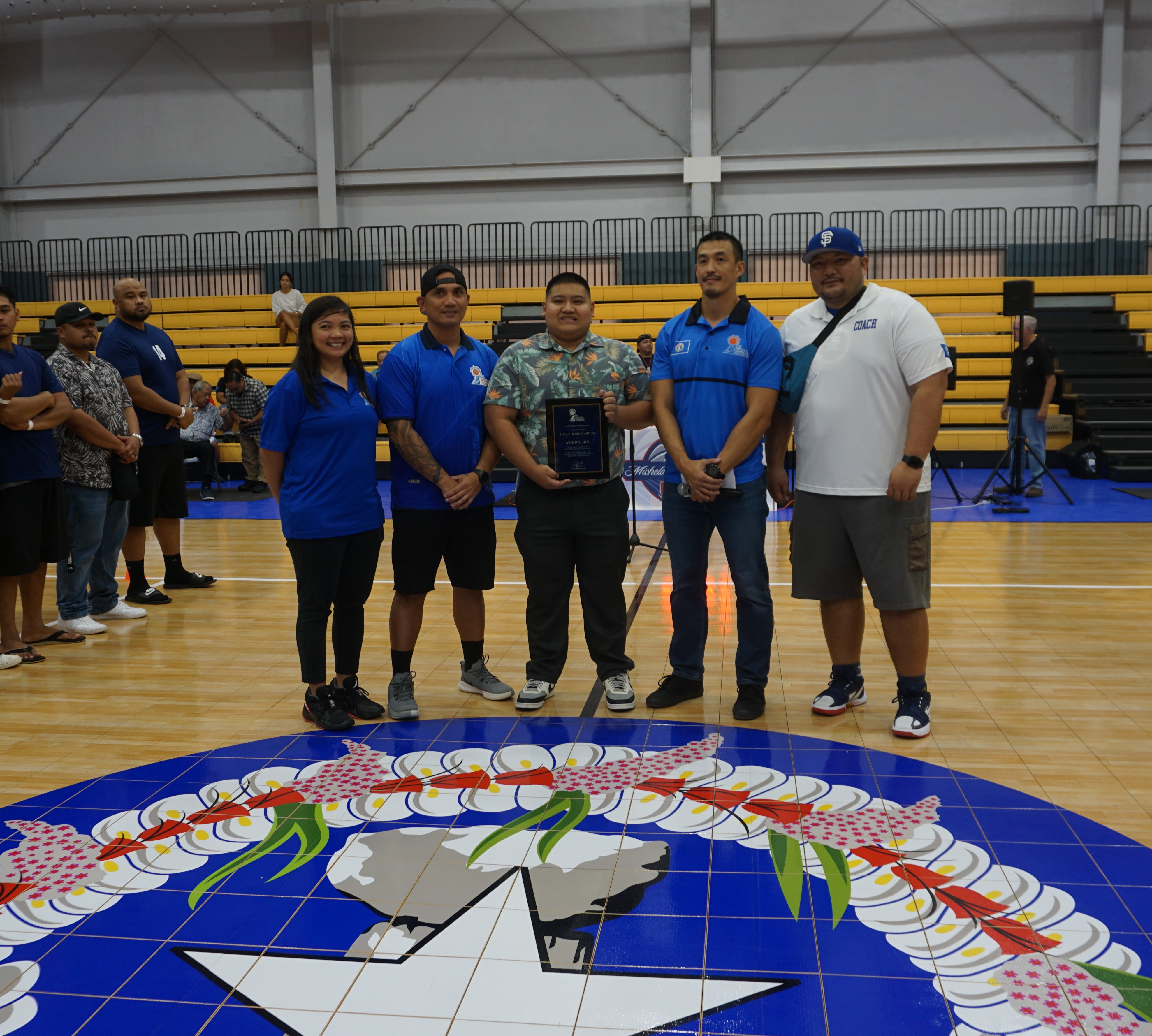 Marc Venus, center, holds a plaque of appreciation for his father, the late Abner Venus, as he poses for a photo with NMI Basketball Federation President James Lee, NMIBF Vice President David Apatang, Marlene Lumabi and Joe Villacrusis.  The former president of the Basketball Association of the Northern Mariana Islands, Abner Venus passed away on Monday. He was 58 years old.