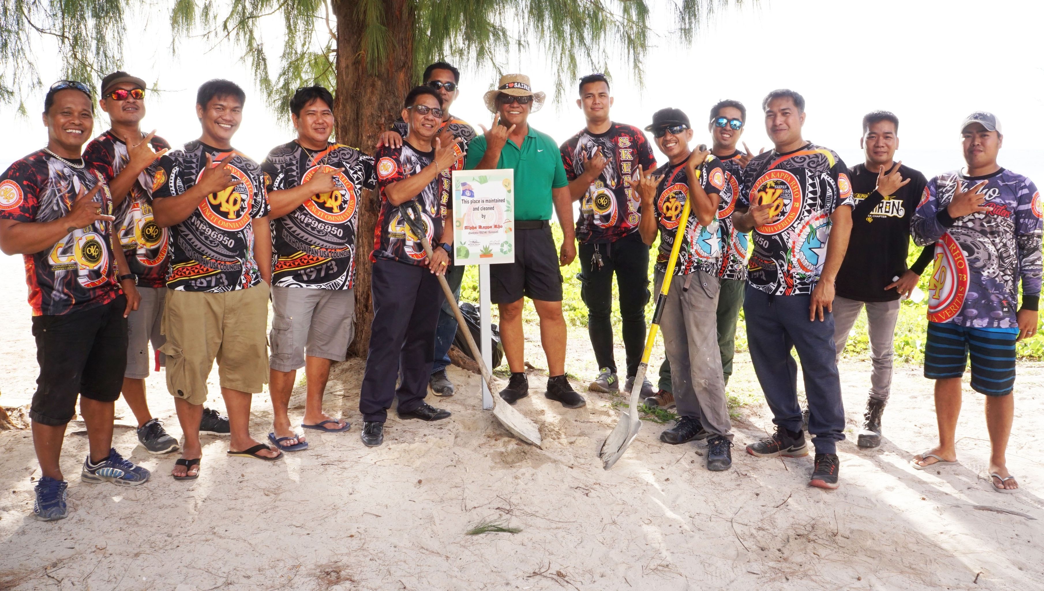 Saipan Mayor RB Camacho and AKRHO members flash the AKRHO sign at Aquarius Beach on Friday.