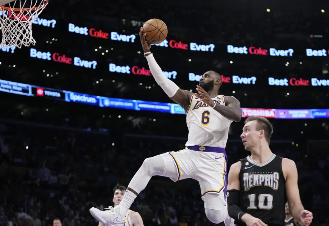 Los Angeles Lakers forward LeBron James, left, shoots as Memphis Grizzlies guard Luke Kennard defends during the first half in Game 3 of a first-round NBA basketball playoff series Saturday, April 22, 2023, in Los Angeles.