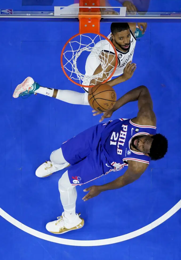 Philadelphia 76ers' Joel Embiid (21) attempts a shot against Brooklyn Nets' Mikal Bridges in the first half during Game 2 in the first round of the NBA basketball playoffs, Monday, April 17, 2023, in Philadelphia.