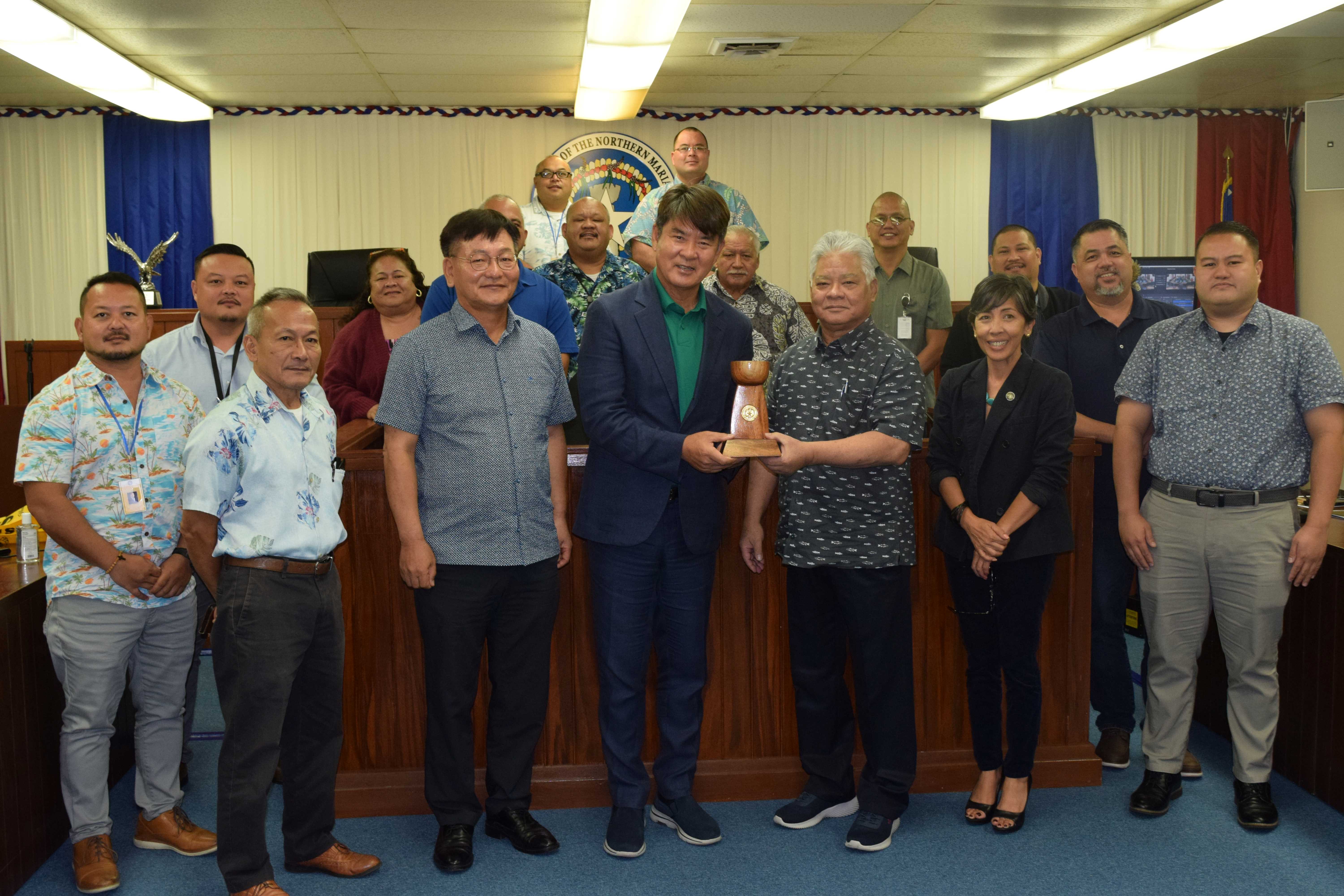 South Korean professional golf player instructor Lim Jin Han, center, receives a token of appreciation from Gov. Arnold I. Palacios as they pose for a photo with House members in the House chamber on Monday.