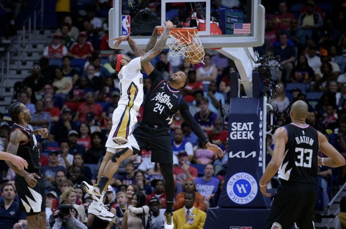 New Orleans Pelicans forward Brandon Ingram (14) dunks on Los Angeles Clippers guard Norman Powell (24) during the first half of an NBA basketball game in New Orleans, Saturday, April 1, 2023.