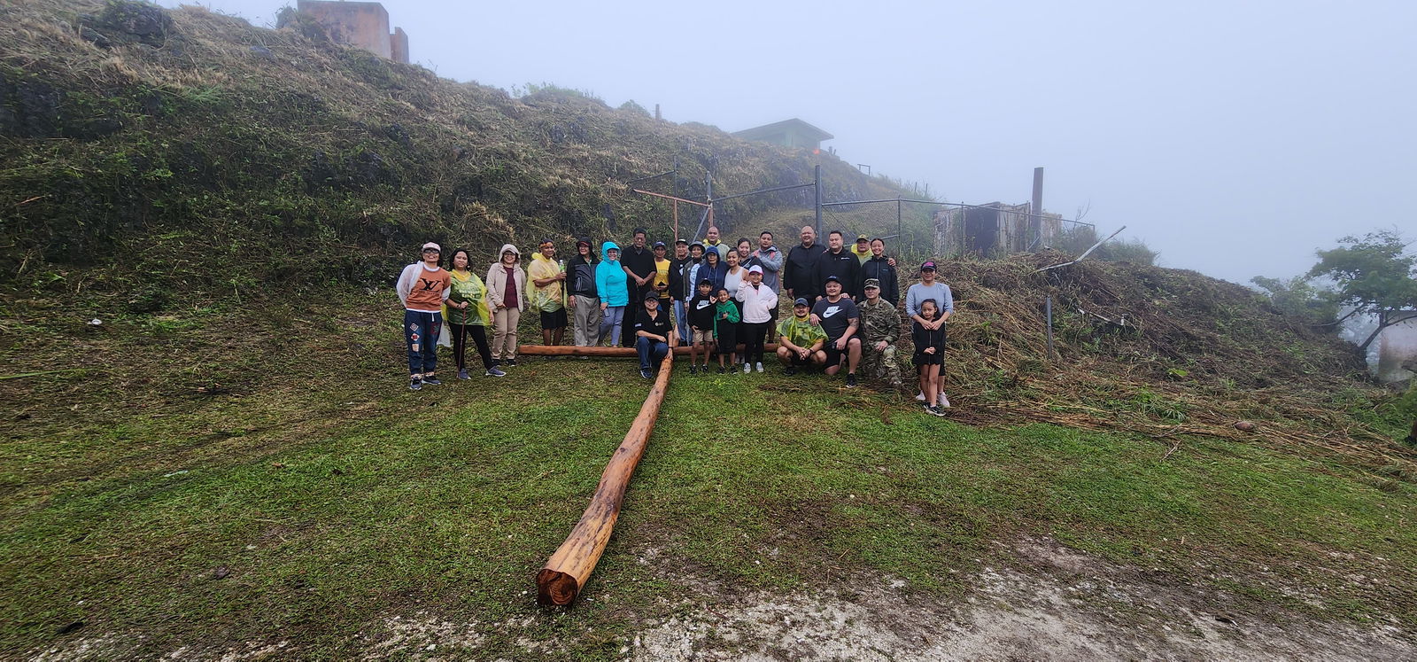 Father Isidro Ogumoro and other devotees pose with the wooden cross that would be erected on Mount Tapochao on Good Friday.