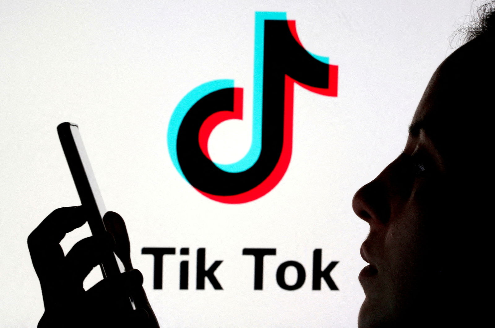 FILE PHOTO: A person holds a smartphone as Tik Tok logo is displayed behind in this picture illustration taken November 7, 2019. REUTERS/Dado Ruvic