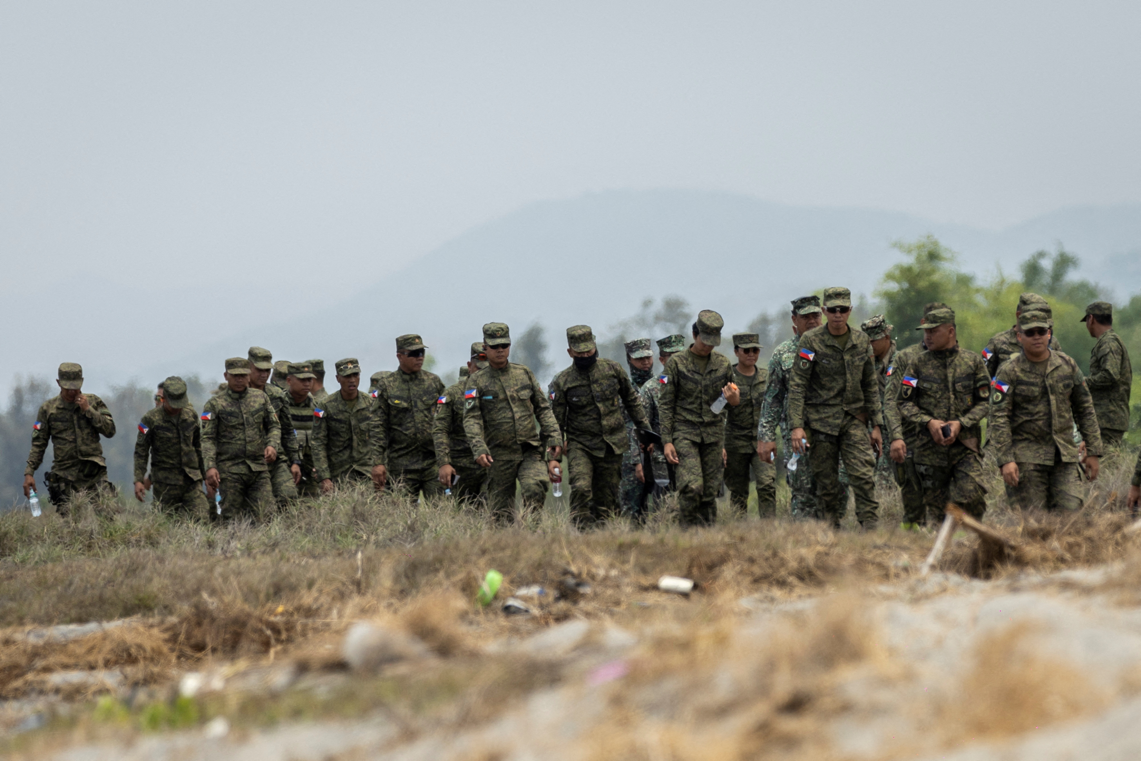 Filipino soldiers walk along the shore of a naval base to watch a live fire exercise in the annual joint military exercises between U.S. and Philippine troops called "Balikatan" or shoulder-to-shoulder, at a naval base in San Antonio, Zambales province, Philippines, April 25, 2023. REUTERS/Eloisa Lopez