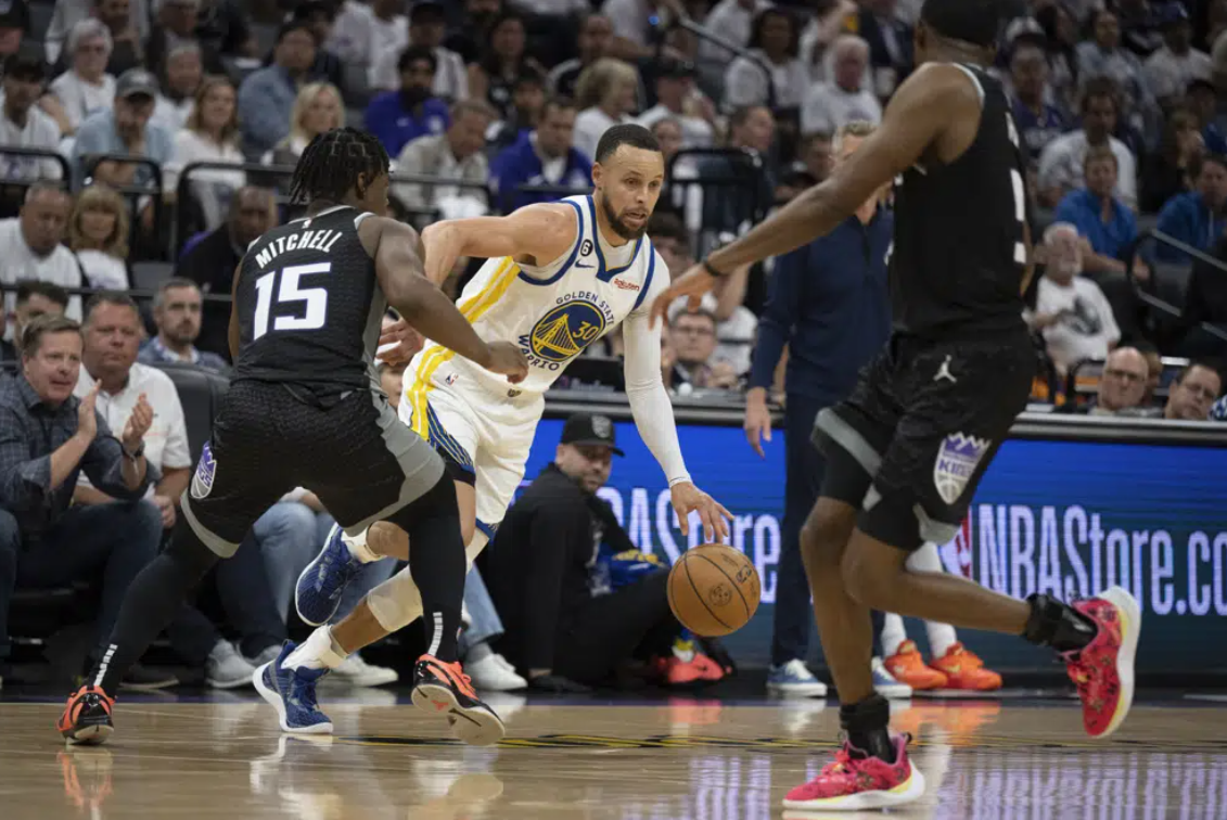 Golden State Warriors guard Stephen Curry (30) tries to dribble past Sacramento Kings guard Davion Mitchell (15) in the third quarter during Game 1 in the first round of the NBA basketball playoffs in Sacramento, Calif., Saturday, April 15, 2023.