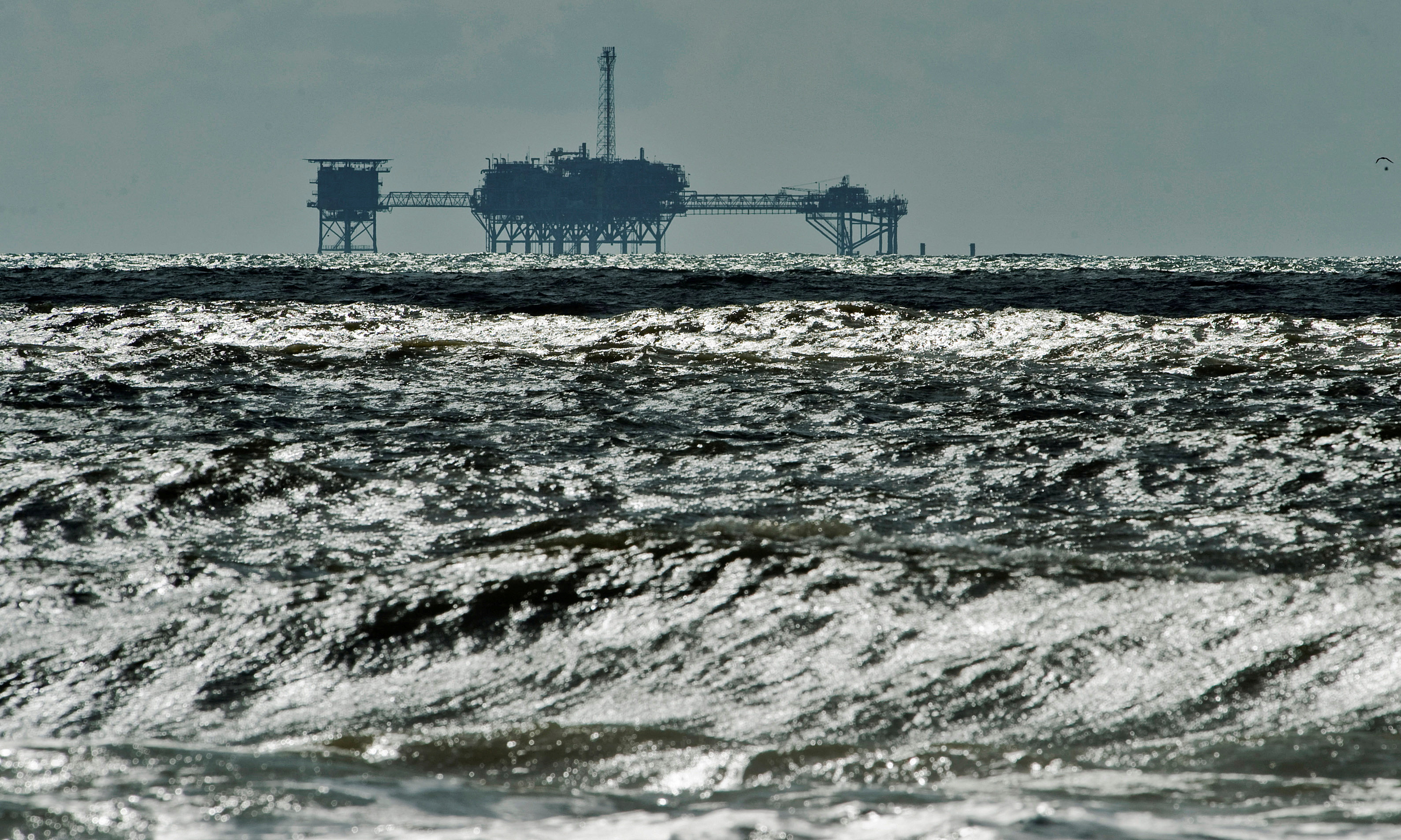 An oil and gas drilling platform stands offshore near Dauphin Island, Alabama, Oct. 5, 2013.