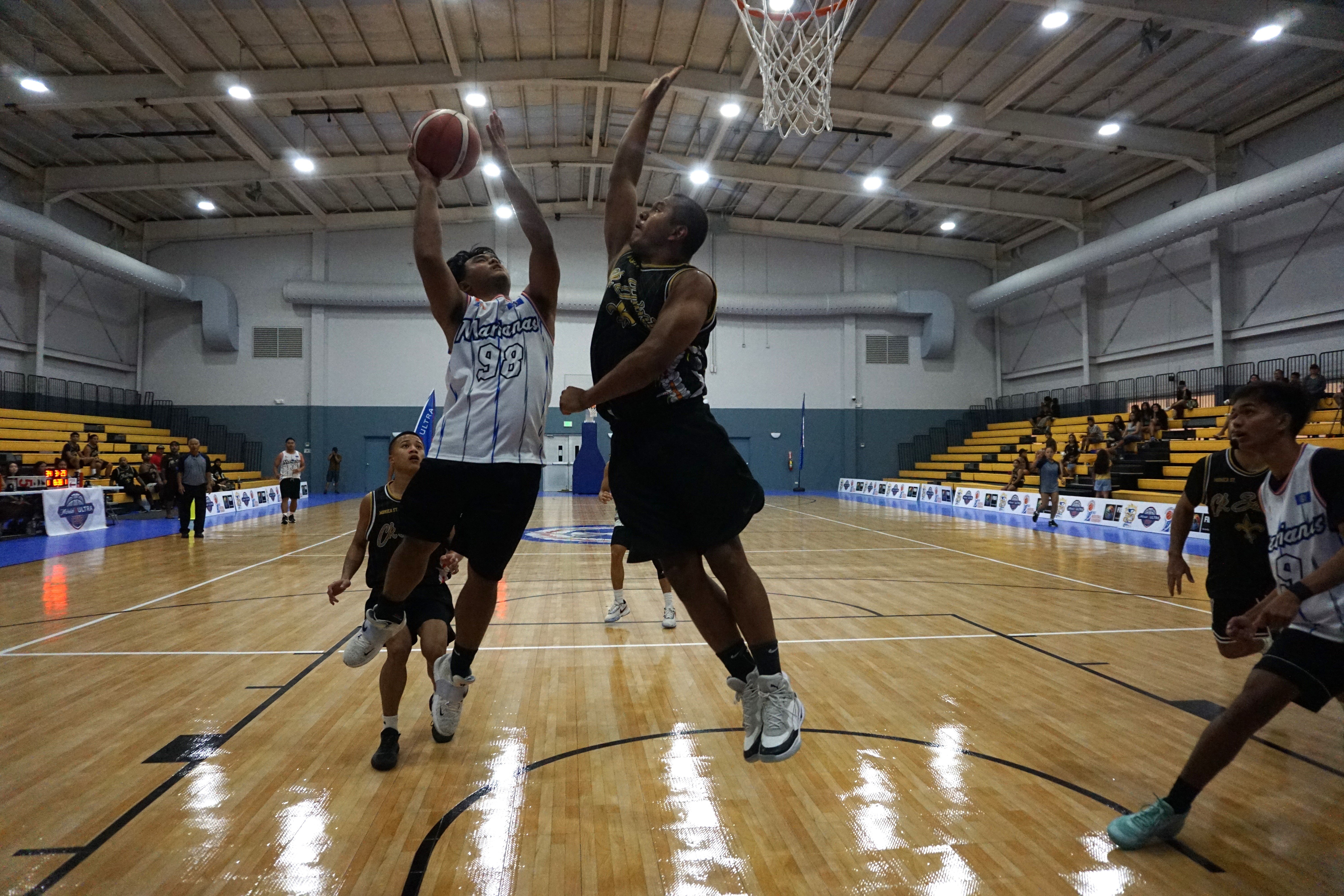 Team Marianas' Greg Sablan goes up for the shot against the CK Saint's Melvin Manibusan during a playoff game of the Michelob Ultra Cup Sunday at the Ada gym.