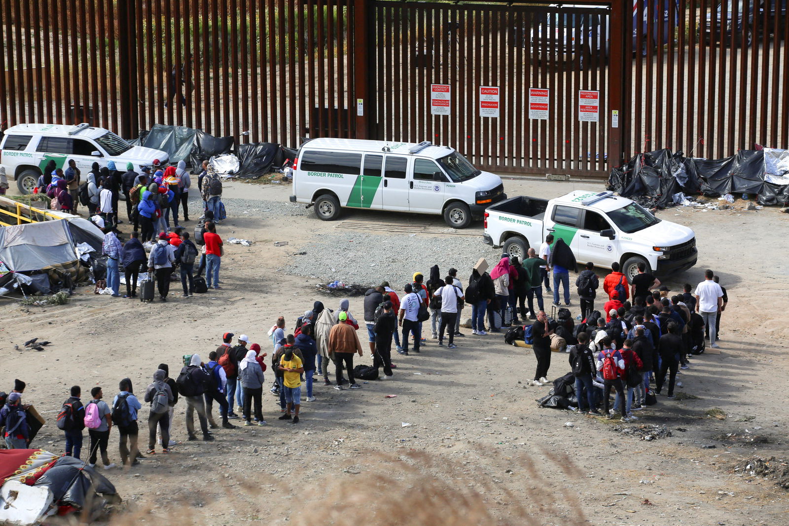 FILE PHOTO: Migrants gather between the primary and secondary border fences in San Diego as the United States prepares to lift COVID-19-era restrictions known as Title 42, that have blocked migrants at the U.S.- Mexico border from seeking asylum since 2020, as seen from Tijuana, Mexico May 8, 2023. REUTERS/Jorge Duenes/File Photo