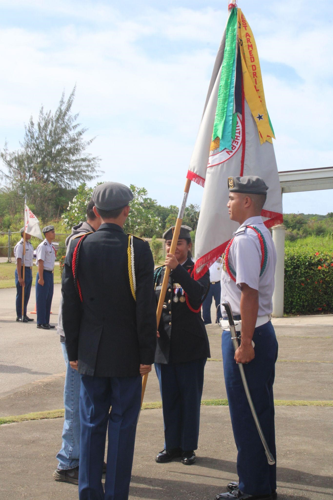 The incoming battalion commander receives the battalion colors from the outgoing battalion C/CSM, the outgoing battalion commander, and the SSHS principal