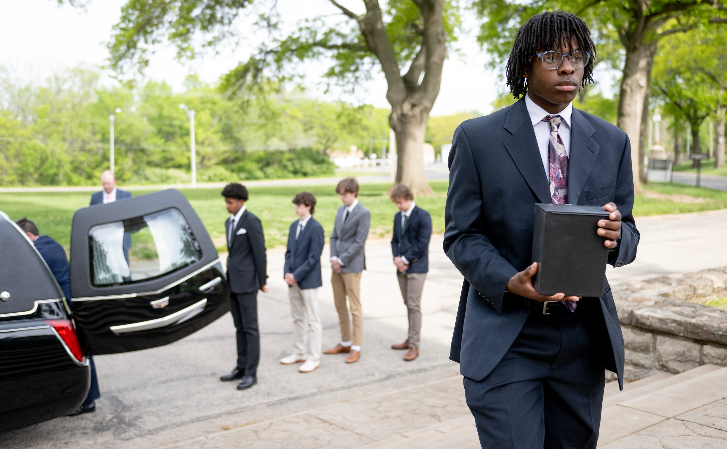 Dominion Yarbrough carries a cremated body to its final resting place during a funeral service for unclaimed deceased persons at the Mount Olivet Catholic Cemetery on Thursday, May 4, 2023, in Raytown, Missouri. Eight high schoolers from Rockhurst High School helped give the deceased a proper burial service. (Nick Wagner/The Kansas City Star/TNS)