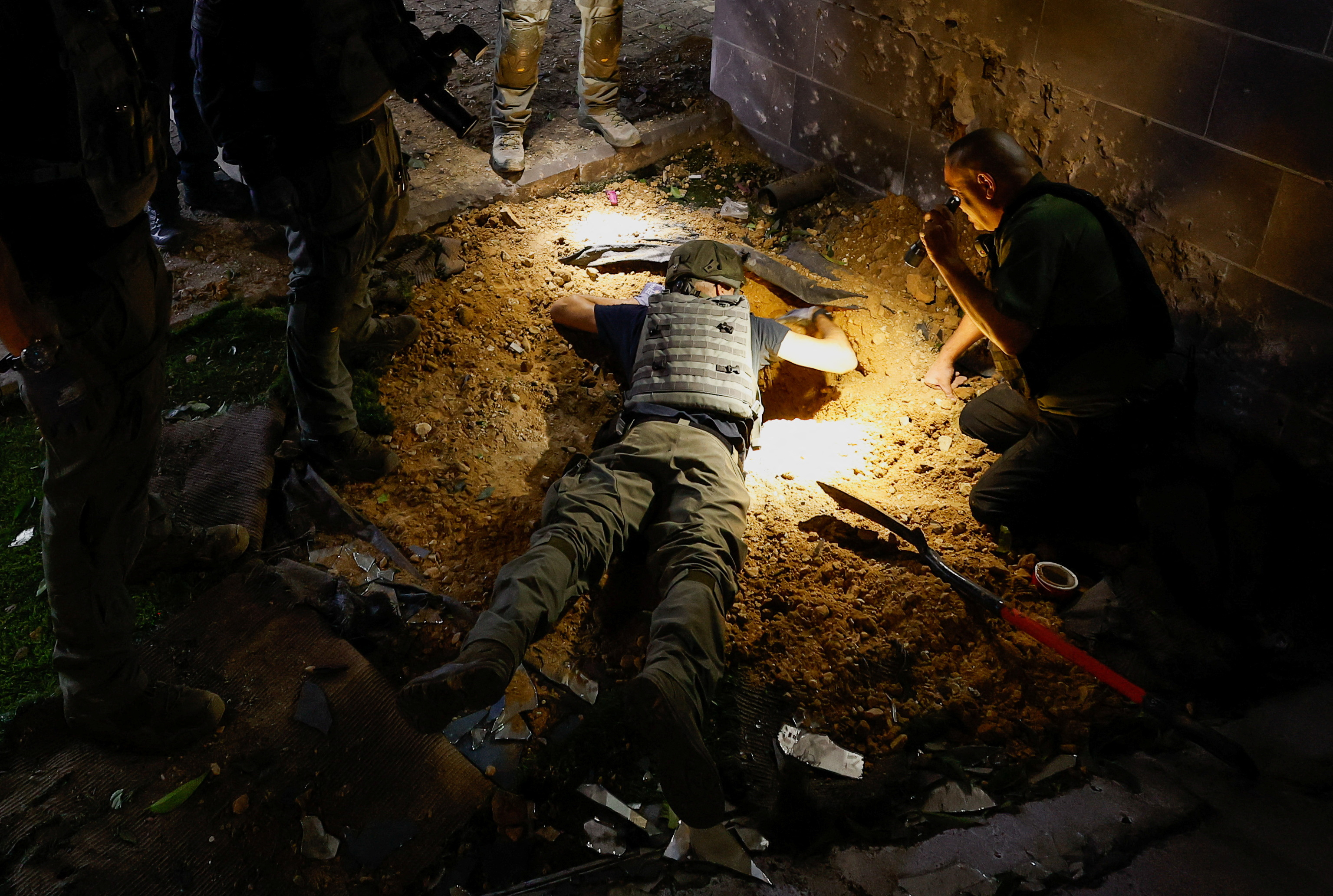 Police officers work to retrieve a rocket, fired from Gaza, that landed near a home in Sderot, Israel May 10, 2023, REUTERS/Ammar Awad