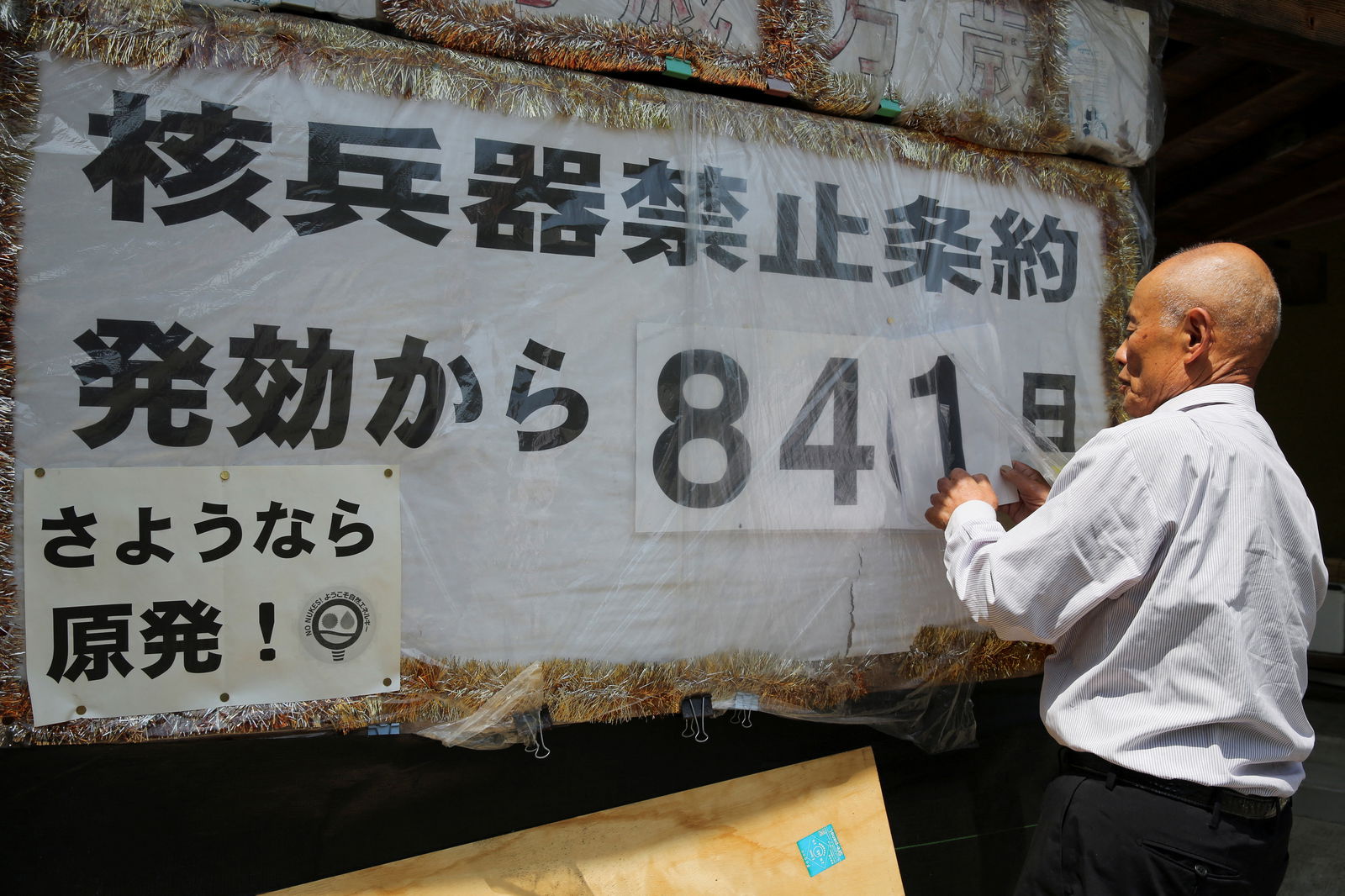 FILE PHOTO: Atomic bomb survivor Toshiyuki Mimaki changes the numbers on a poster counting the days since the Nuclear Weapon Ban Treaty came into effect at his home in Yamagata district, Hiroshima prefecture, western Japan May 12, 2023. REUTERS/Sakura Murakami