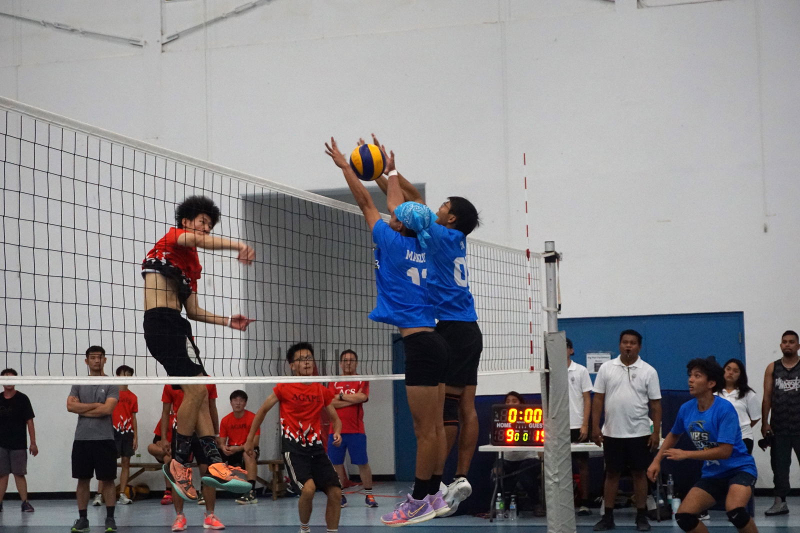 Two Marianas High School defenders extend for the block against the attempted spike of Agape Christian School’s David Zhao during the boys high school division championship game of the NMIVA-PSS Interscholastic Volleyball League at the MHS gym on April 29, 2023. MHS won the title.