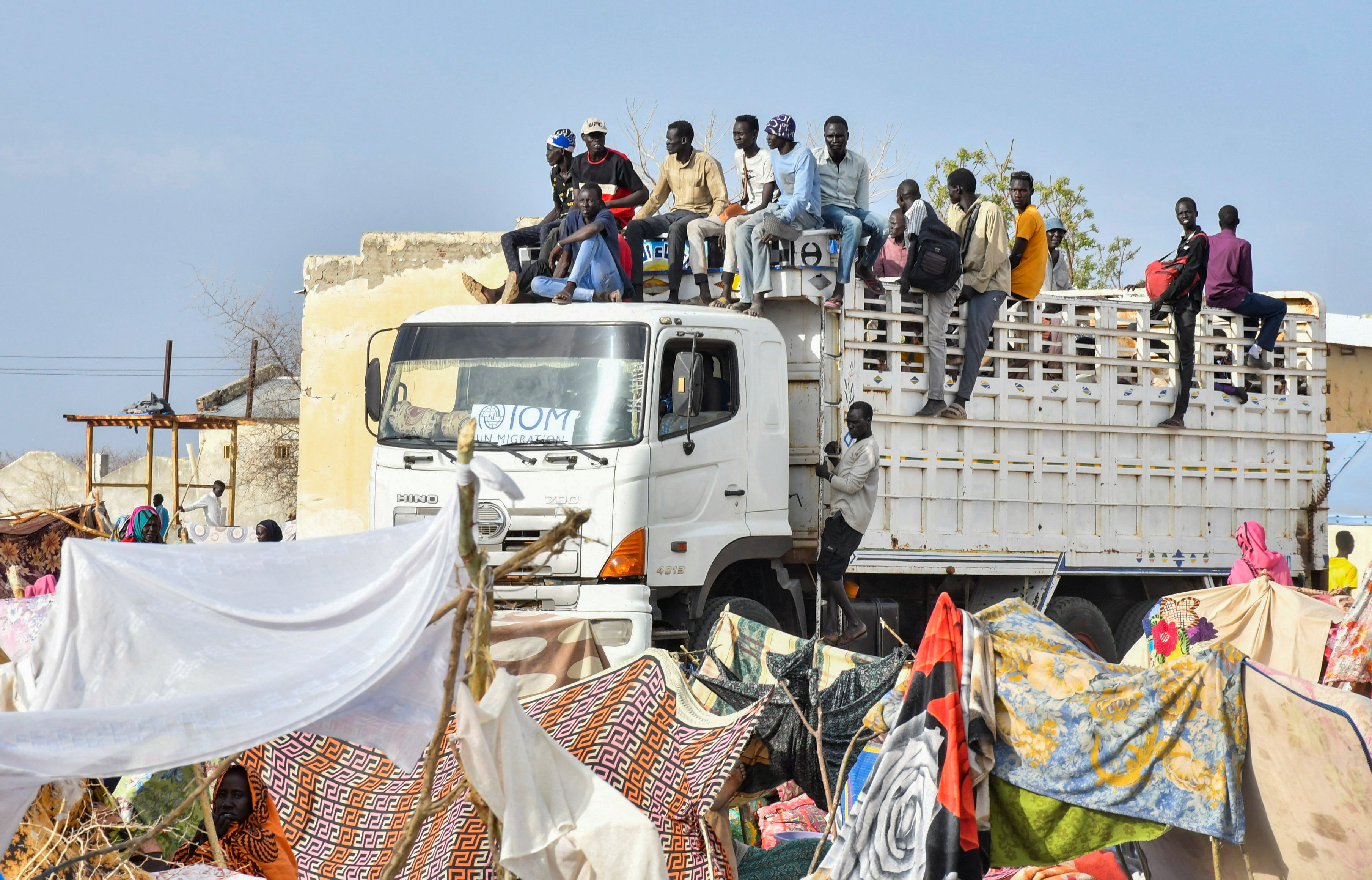 FILE PHOTO: Civilians who fled the war-torn Sudan following the outbreak of fighting between the Sudanese army and the paramilitary Rapid Support Forces (RSF) arrive atop a truck at the United Nations High Commissioner for Refugees (UNHCR) transit centre in Renk, near the border crossing point in Renk County of Upper Nile State, South Sudan May 1, 2023. REUTERS/Jok Solomun