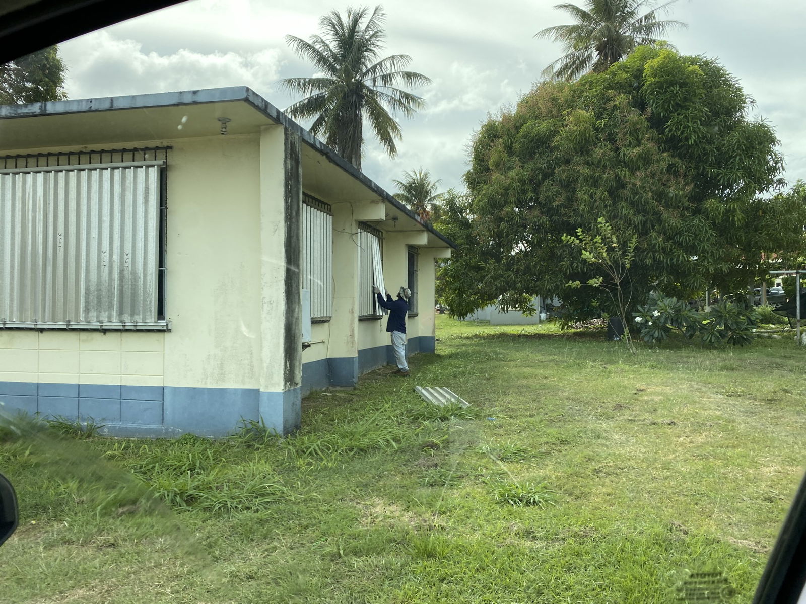 A man installs shutters on a house's windows in Dandan on Monday.