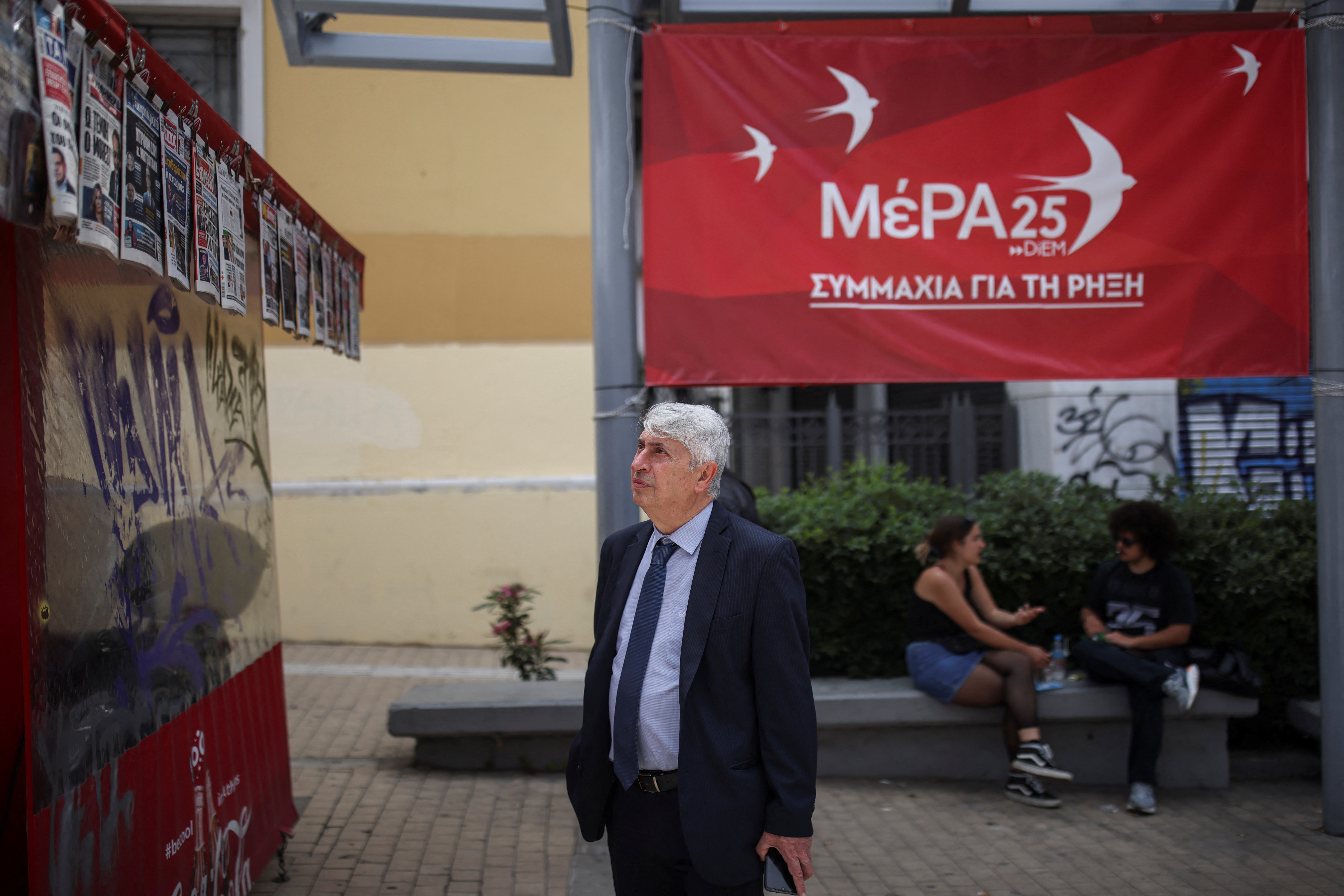 A man reads newspaper headlines next to the MeRA25 party pre-election kiosk in Athens, Greece, May 18, 2023. REUTERS/Stelios Misinas
