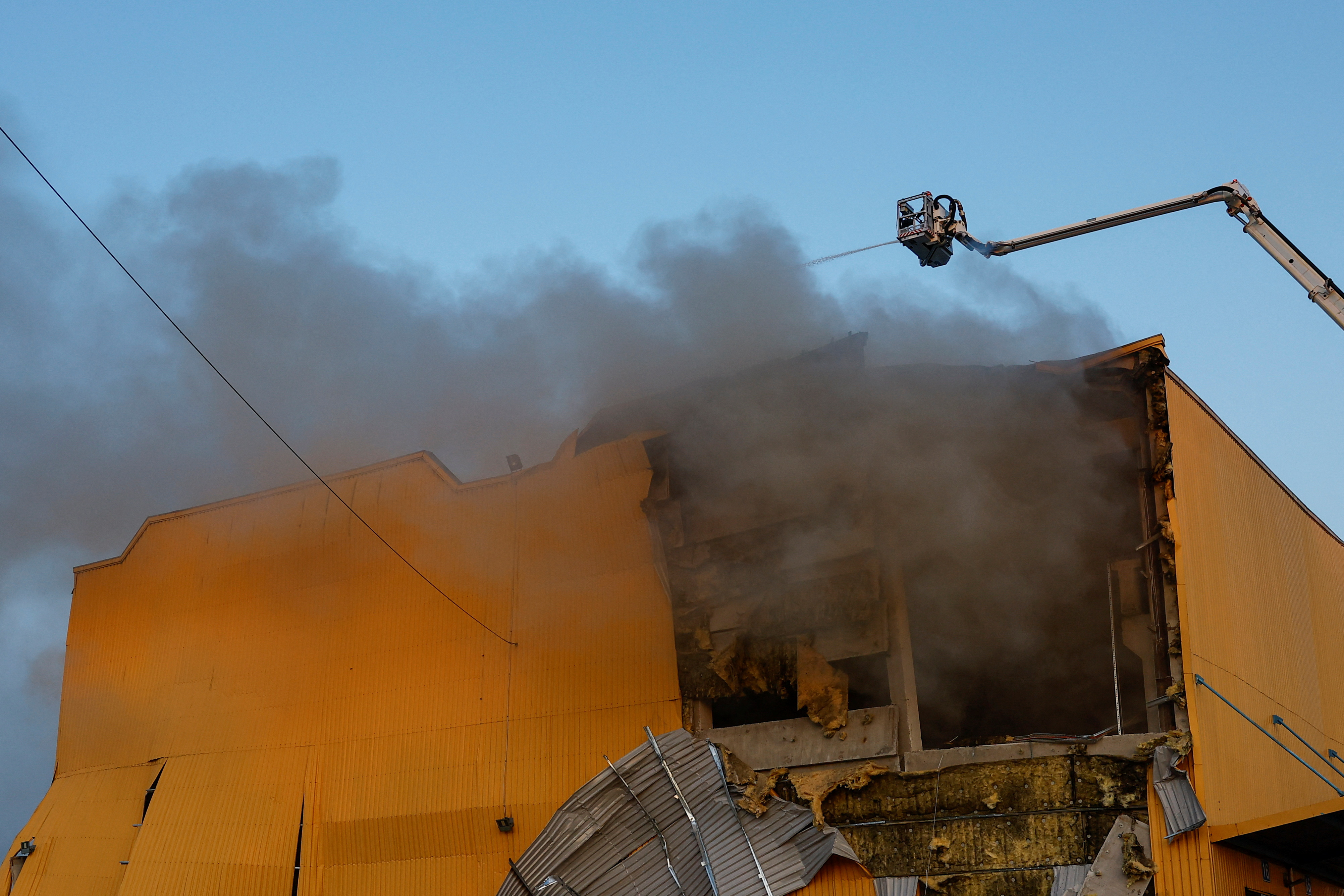 Firefighters work at a site of a tobacco factory damaged during Russian suicide drone strike, amid Russia's attack on Ukraine, in Kyiv, Ukraine May 28, 2023. REUTERS/Valentyn Ogirenko.