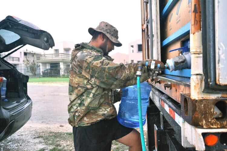 Mark Blas fills his five-gallon container from a water tank Tuesday, May 30, 2023, at the Mongmong-Toto-Maite Mayor’s Office.   